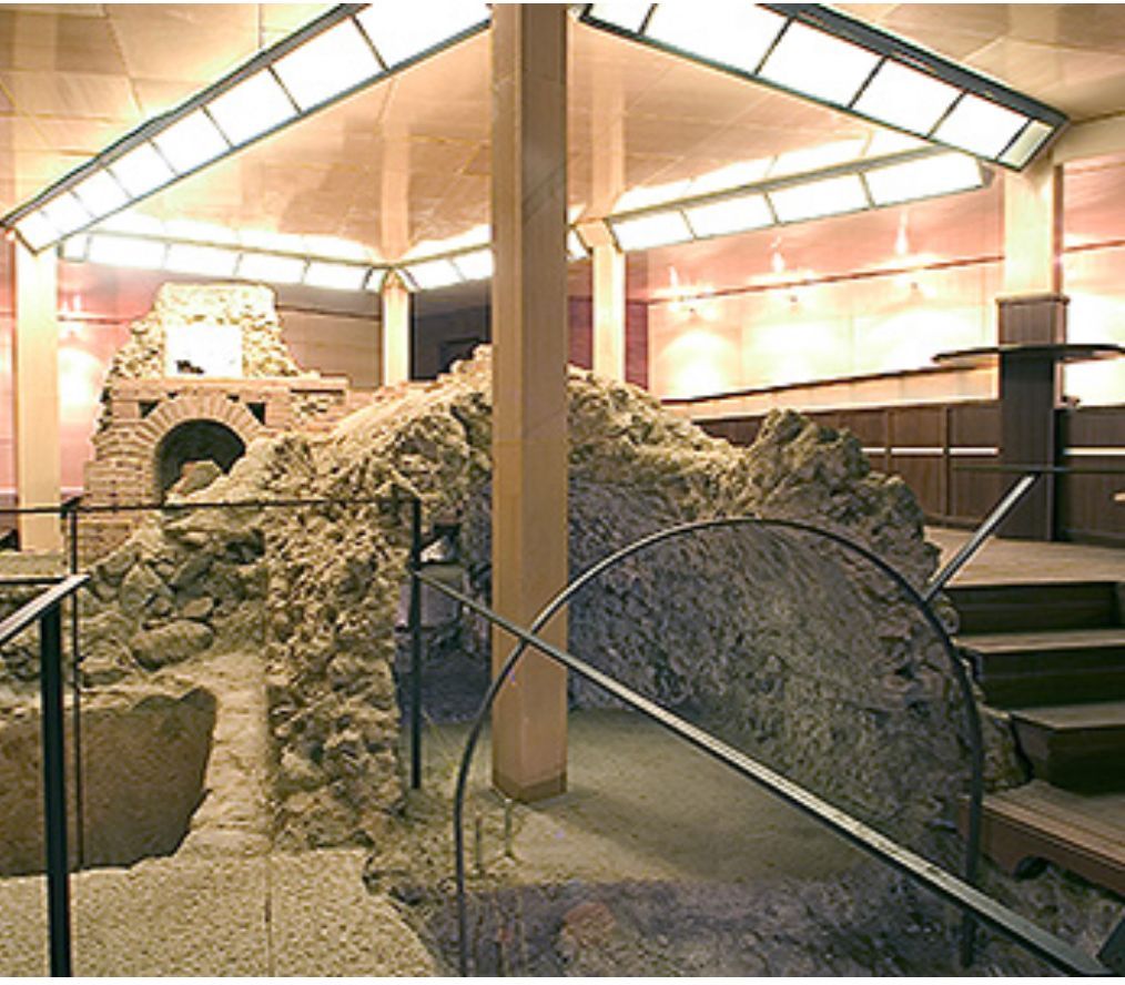 A room with stairs leading up to a stone archway