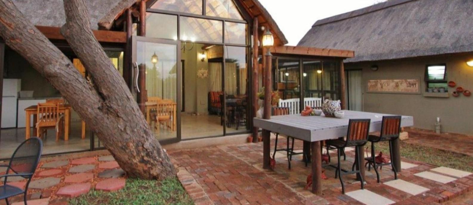 a patio with a table and chairs in front of a house