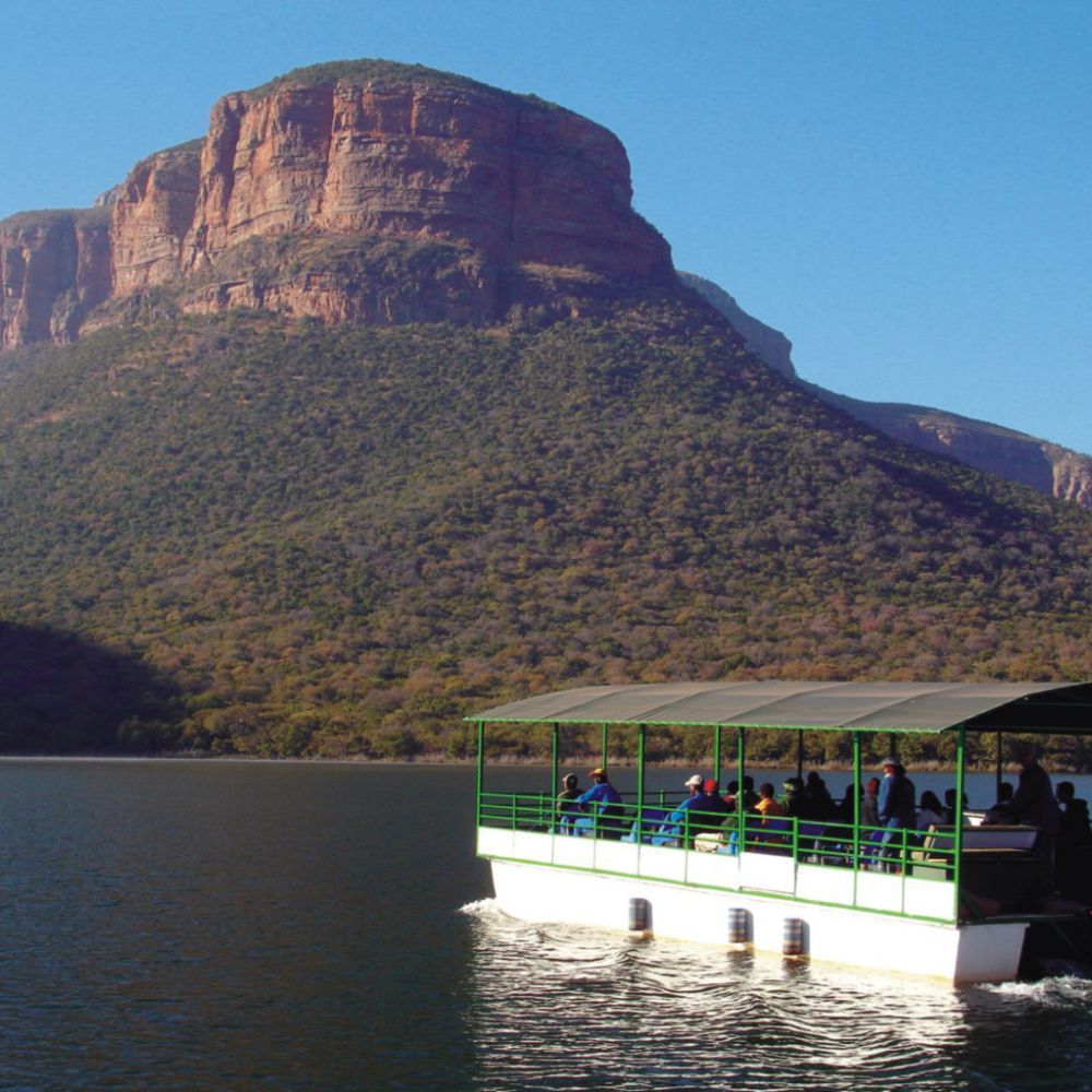 a boat is floating on a lake with a mountain in the background