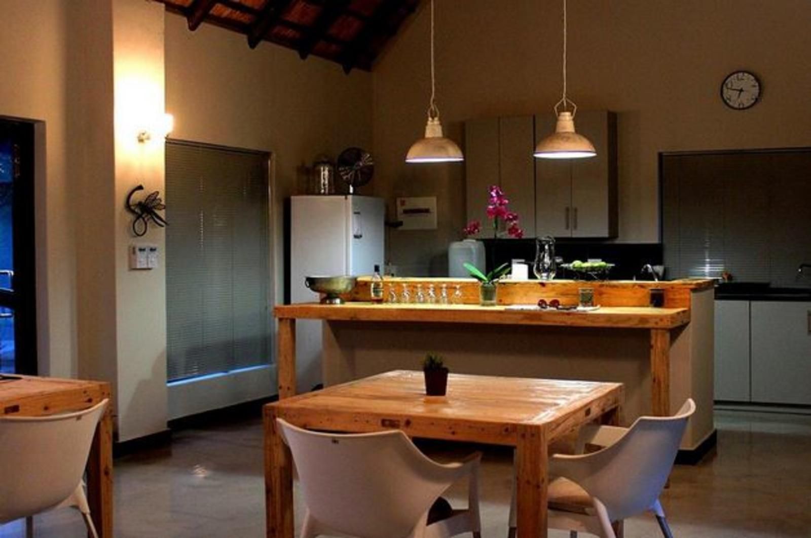 a kitchen with a table and chairs and a clock on the wall