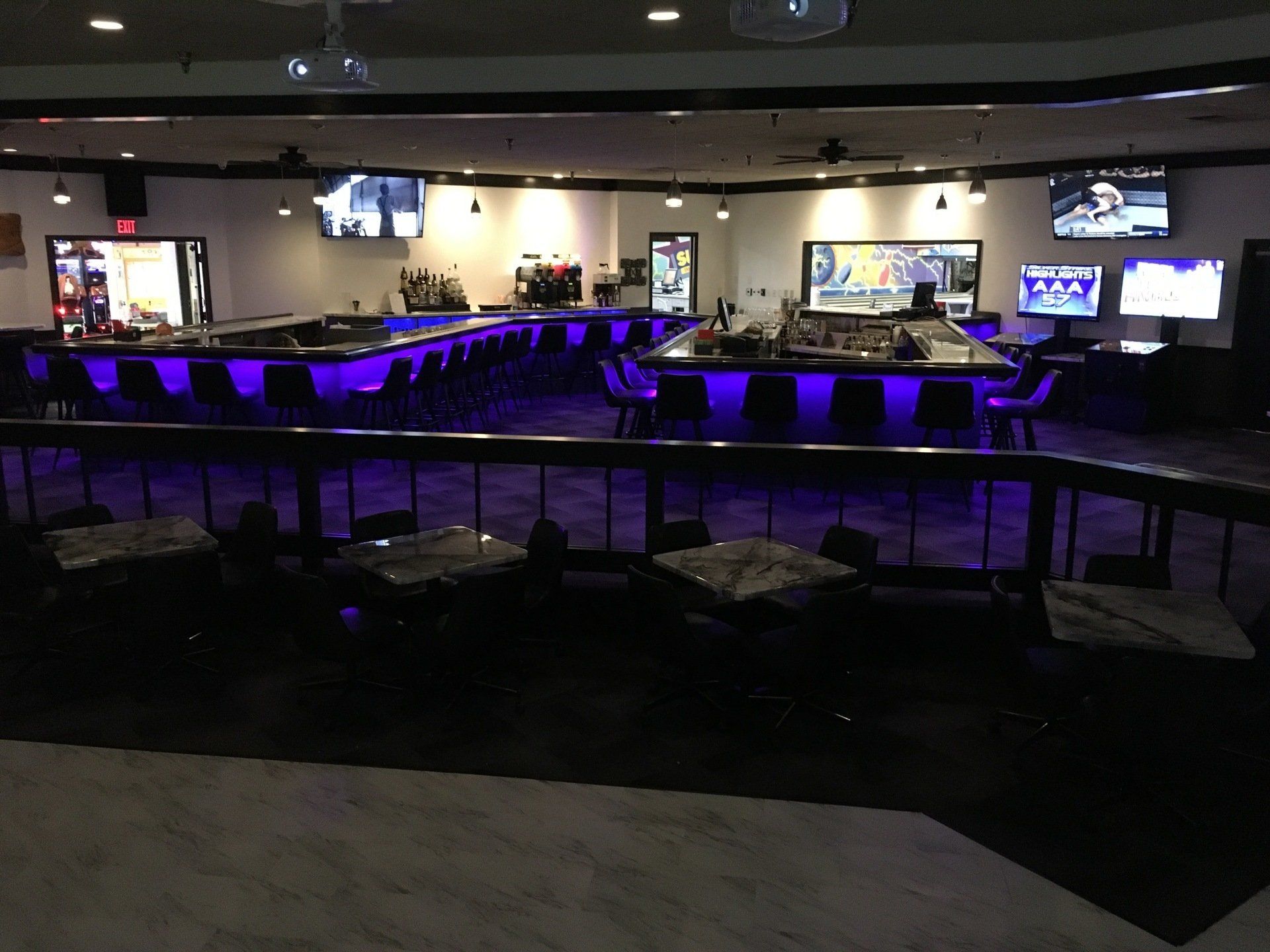 A large room with tables and chairs and purple lights