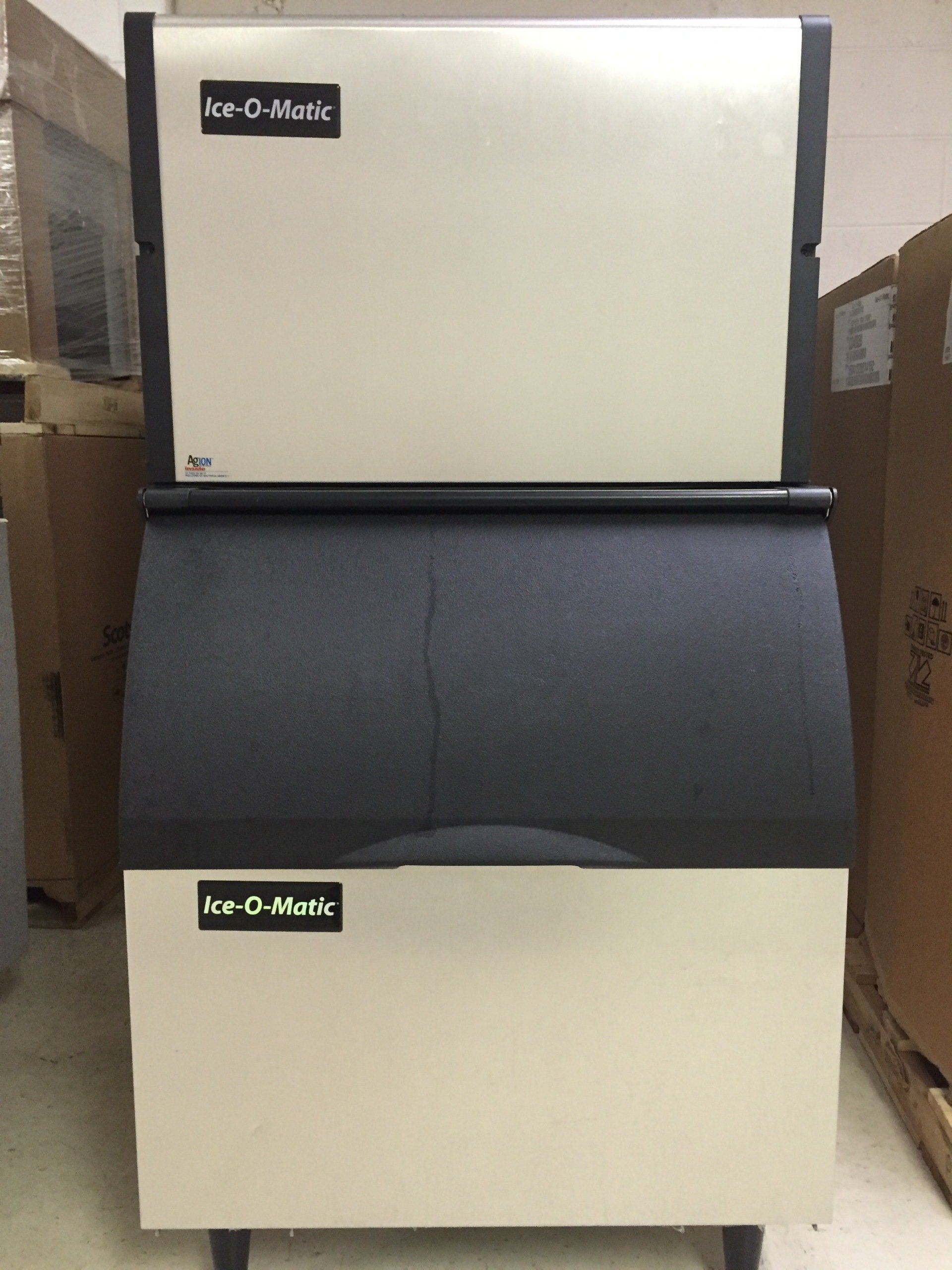 A white and black ice maker that says ice-o-matic on it