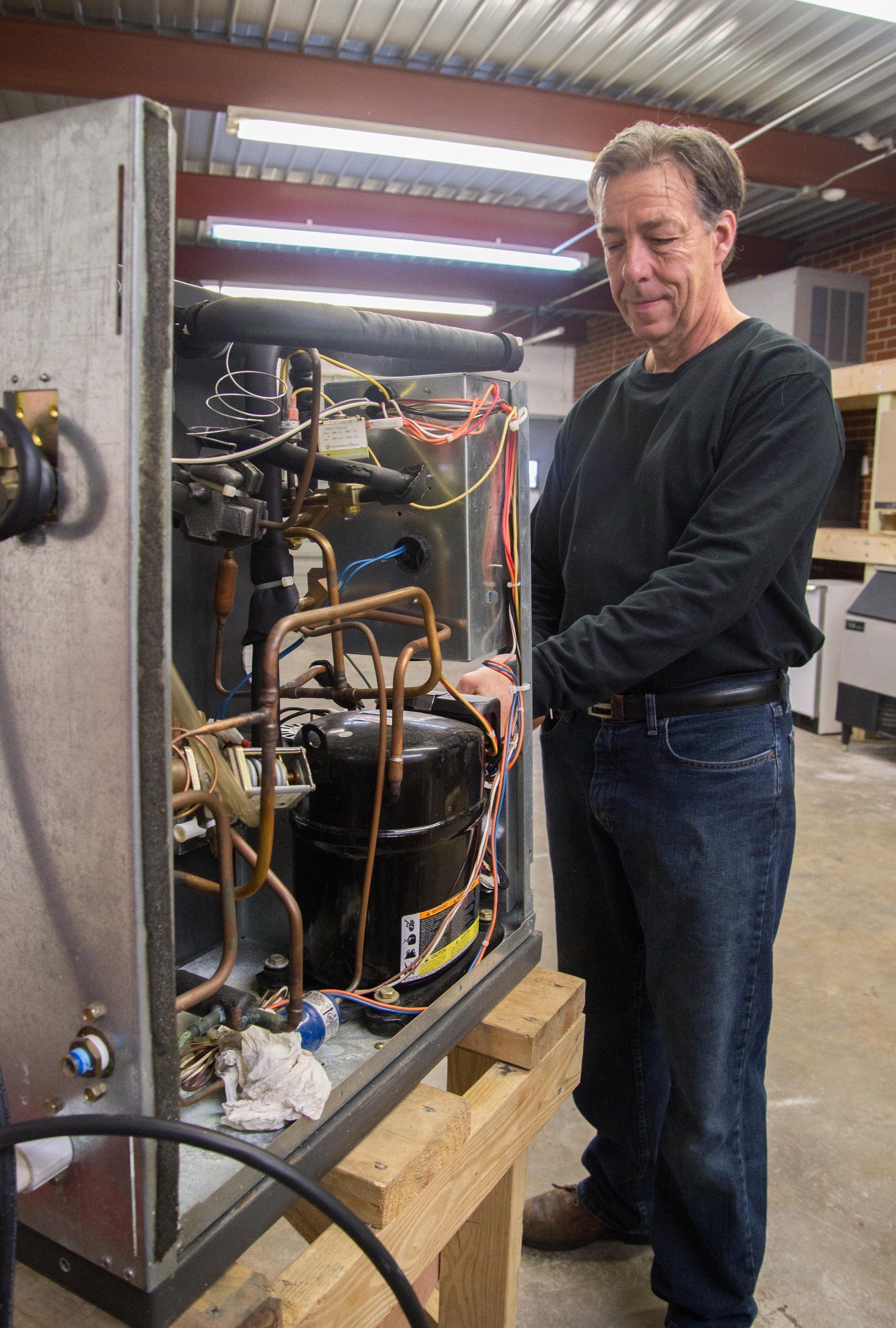 A man is working on a machine in a warehouse.