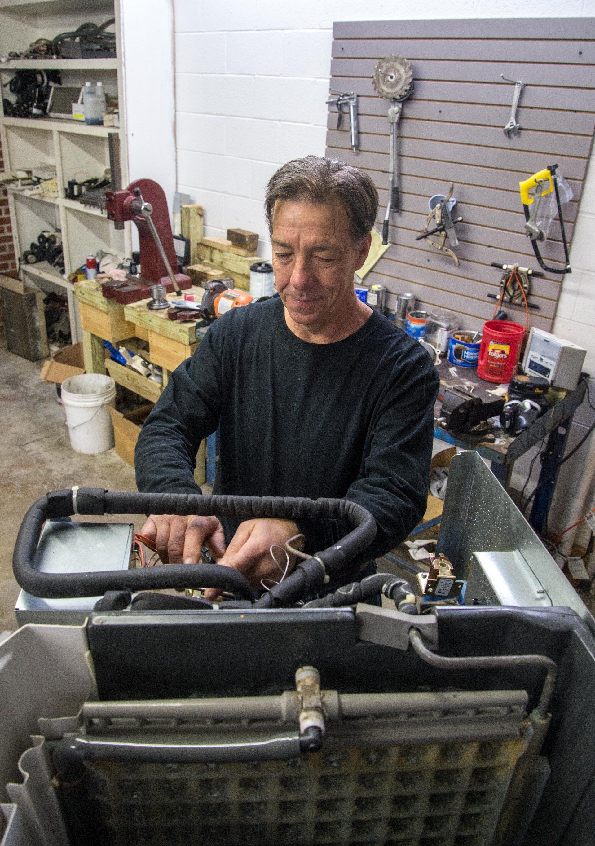 A man is working on a machine in a garage.