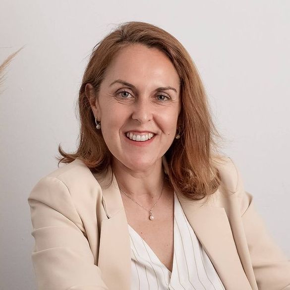 Una mujer sostiene una taza de café y sonríe.