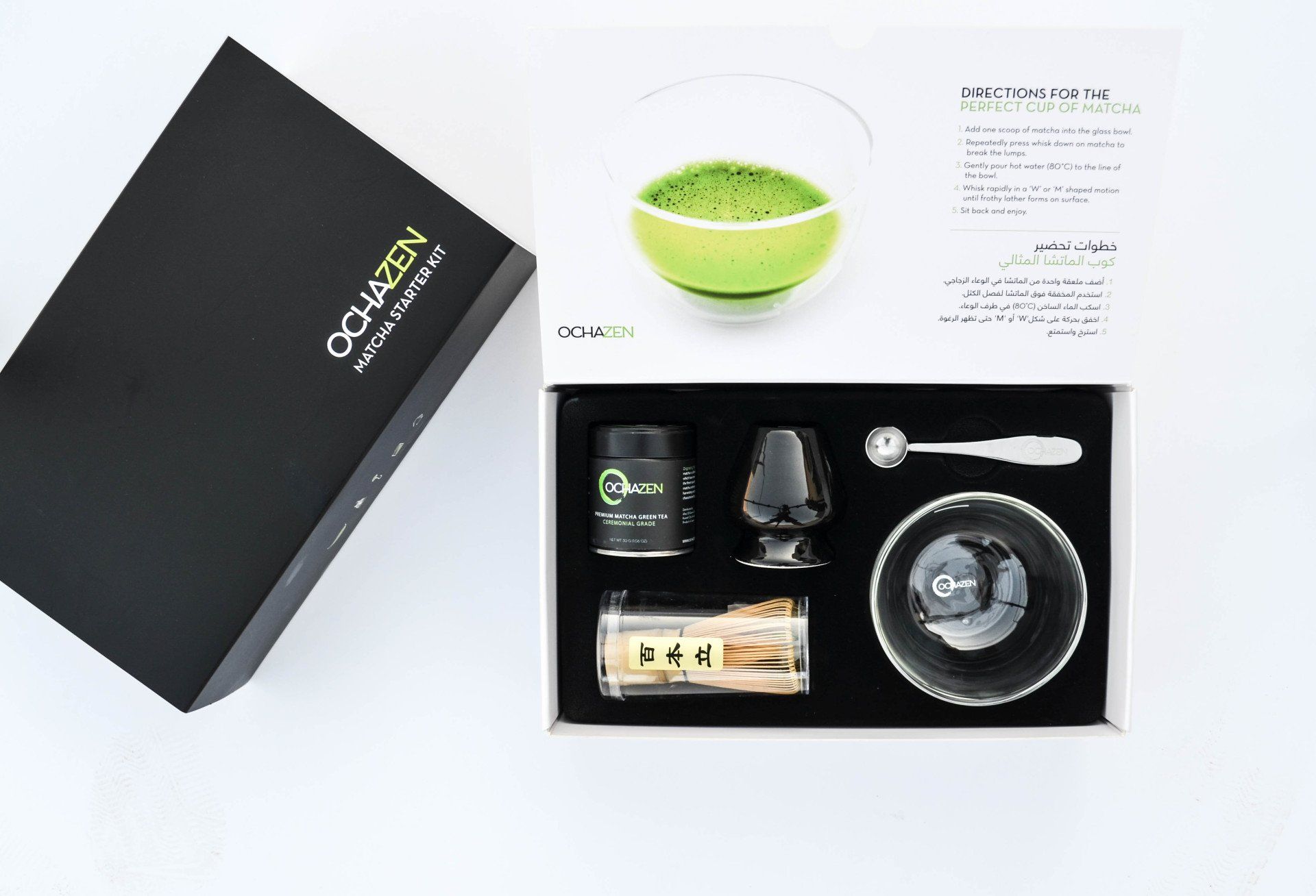 Open matcha tea set box with powder, tools, and a prepared cup.
