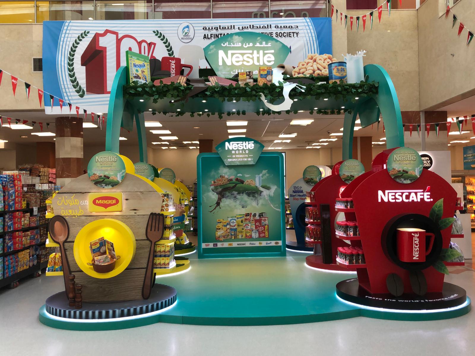 Nestlé promotional display in a supermarket. Featuring product displays, teal and red accents.