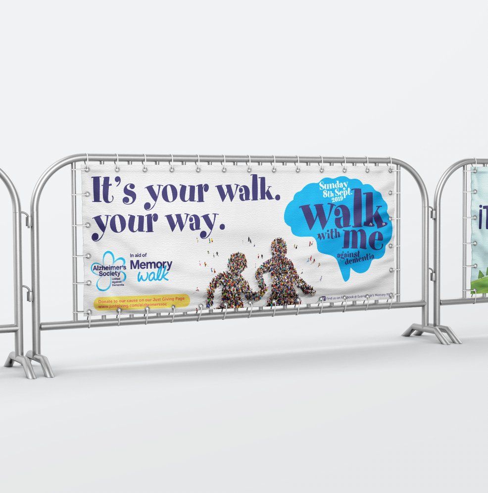 Banner on metal barricade for Memory Week event; text reads 