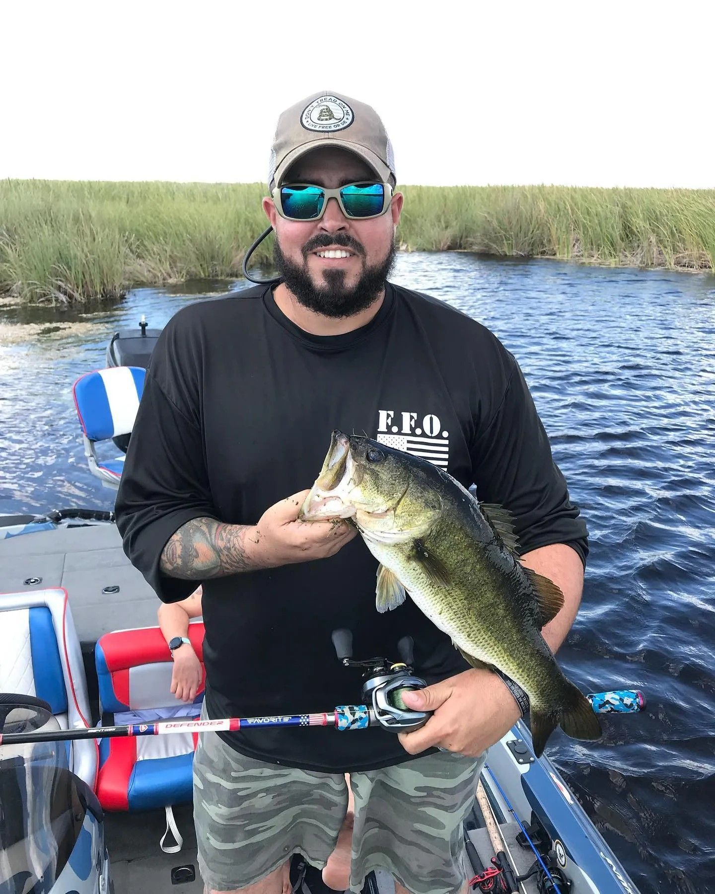 A man is holding a large fish on a boat.