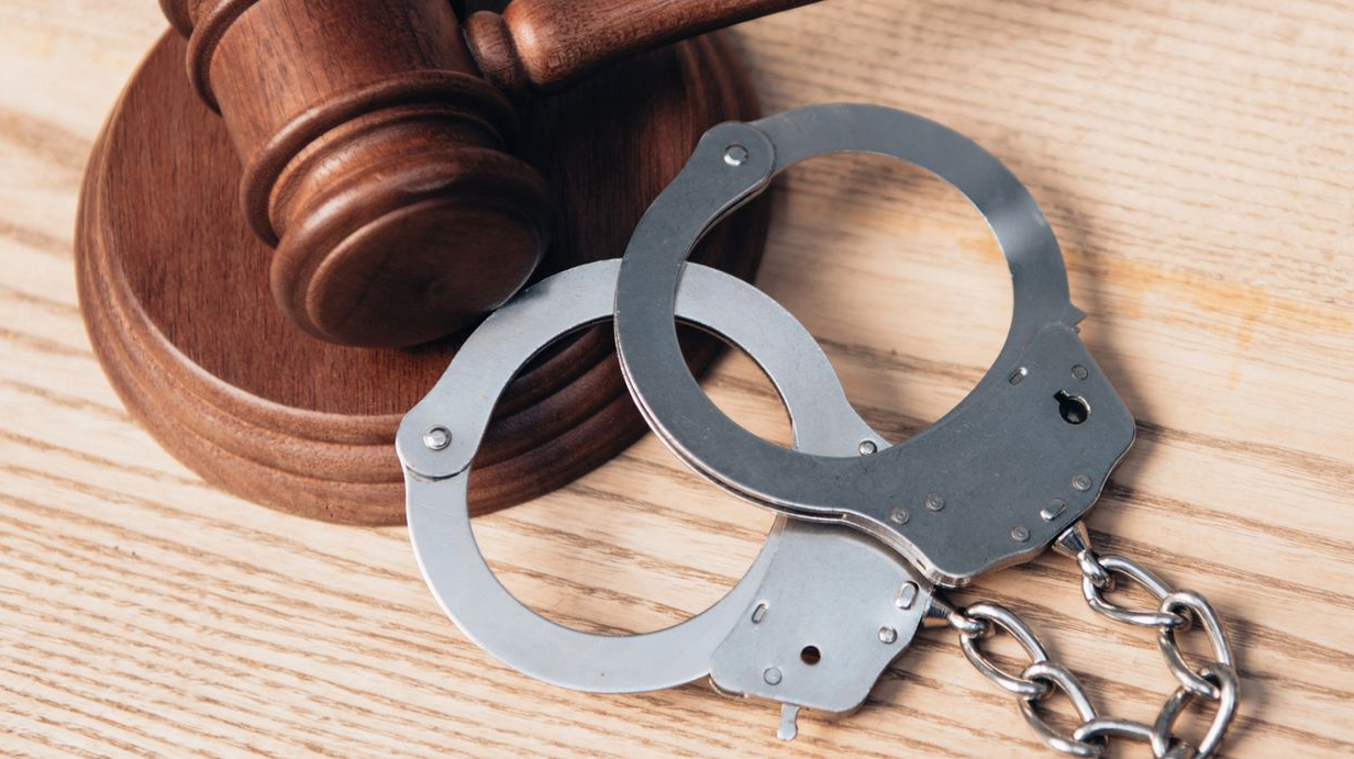 Manette e un martelletto di legno su una superficie di legno chiaro.