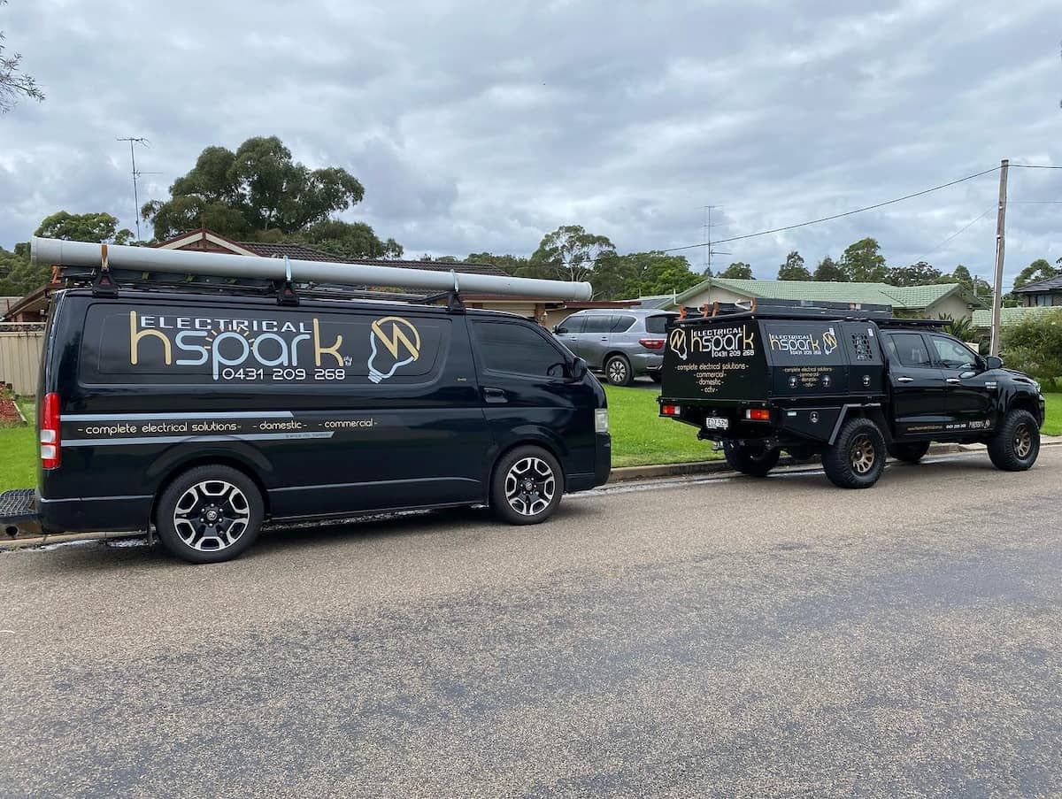 Black Work Vehicles, a Van and a Truck, Parked on a Residential Street — Hspark Electrical PTY LTD in Camden, NSW