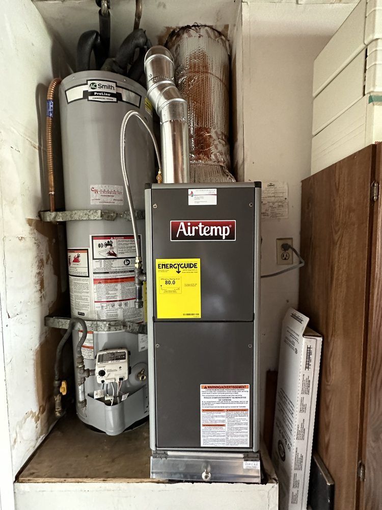 Airtemp furnace and water heater inside a utility closet.