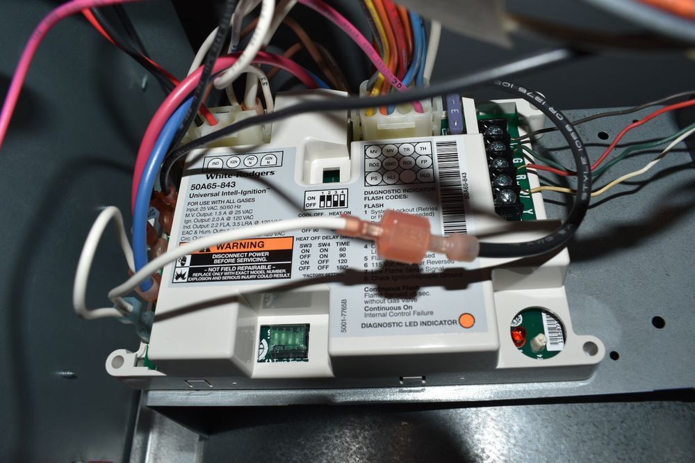 Furnace control board with various colored wires and terminal connectors.