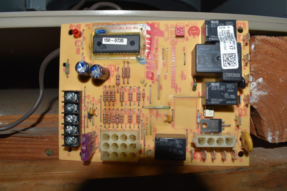 Printed circuit board, tan with various electronic components. Terminal blocks and relays are visible.