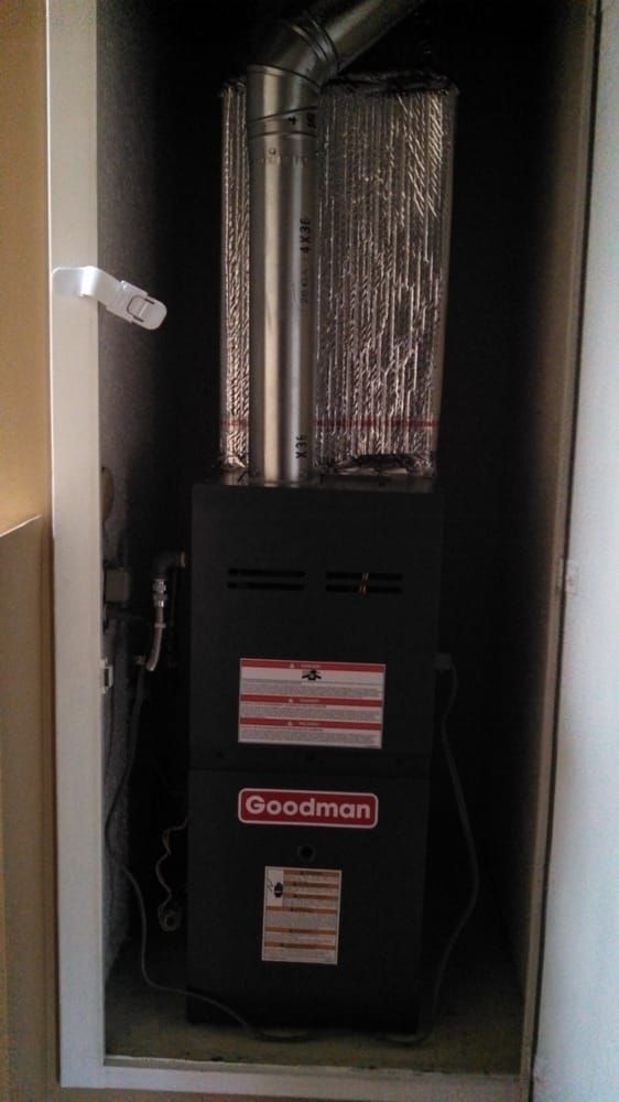 Goodman furnace inside a utility closet, with ductwork.