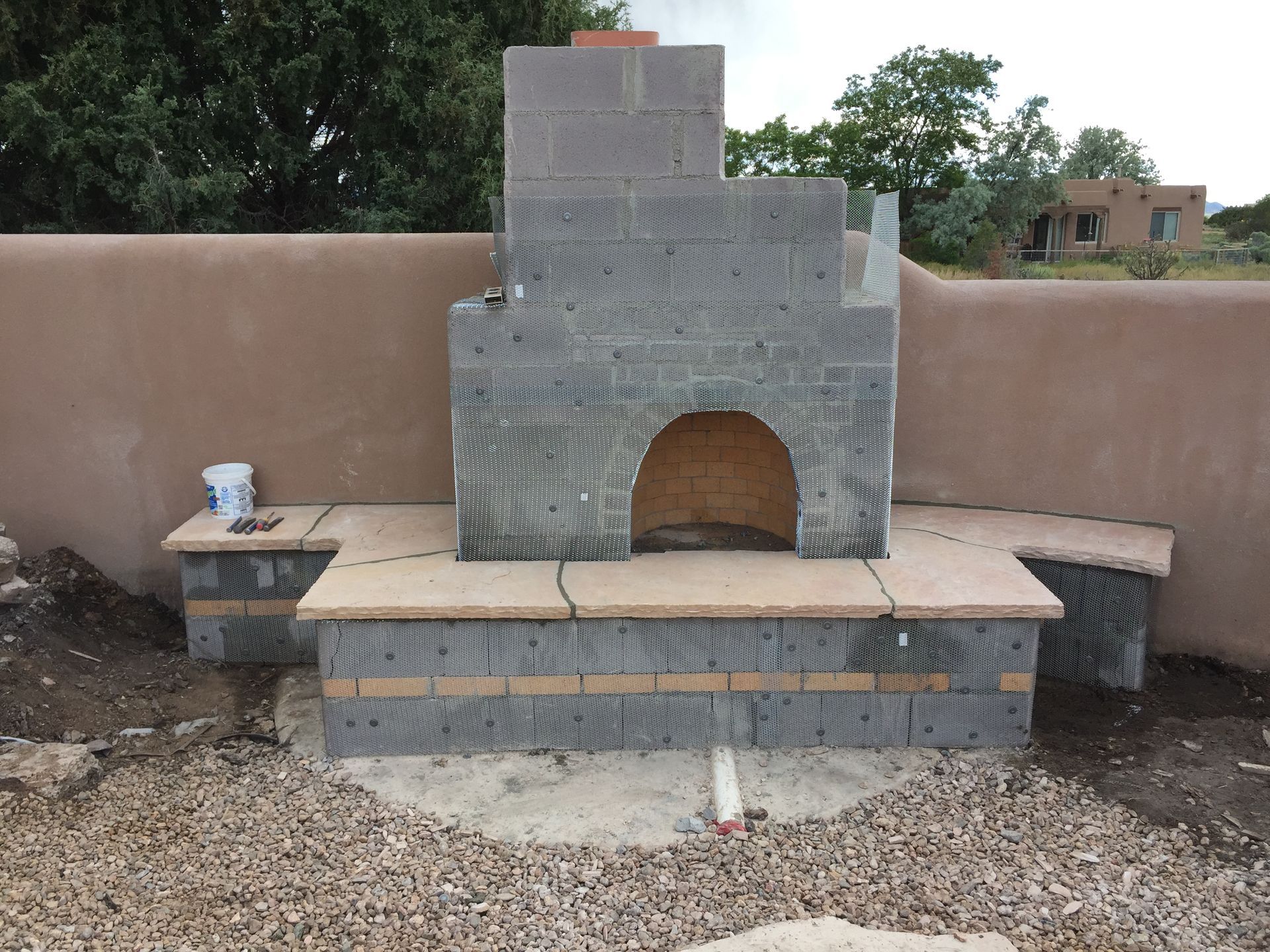 Outdoor Santa Fe style fireplace with custom plaster finish in Santa Fe NM