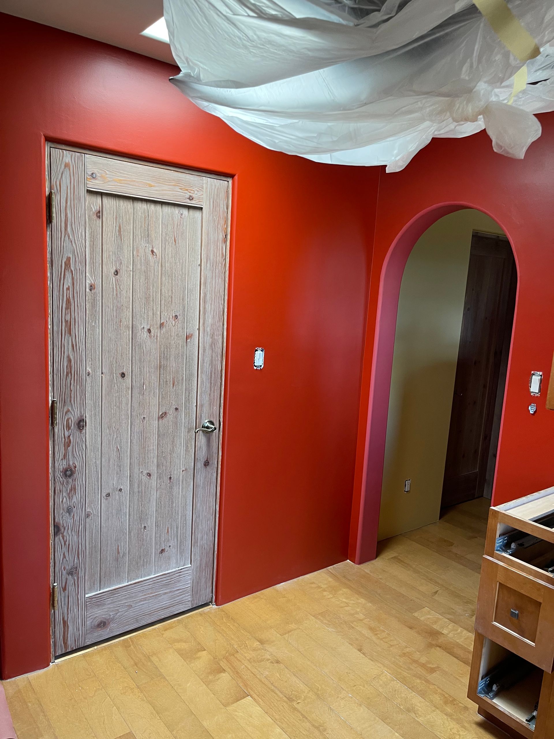 Custom interior painting with bold red color and arched entryway in Eldorado NM