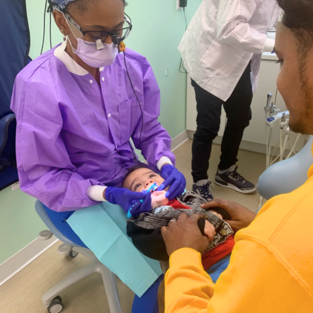 Dr Mensah applying pediatric fluoride treatment during appointment in Tarrytown NY