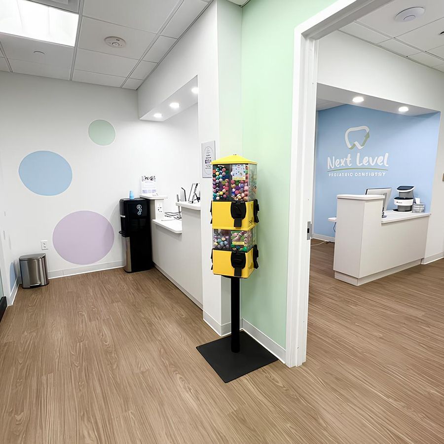 Pediatric dentist office in Hastings-On-Hudson with colorful walls, gumball machine, and welcoming reception area at Next Level Pediatric Dentistry.