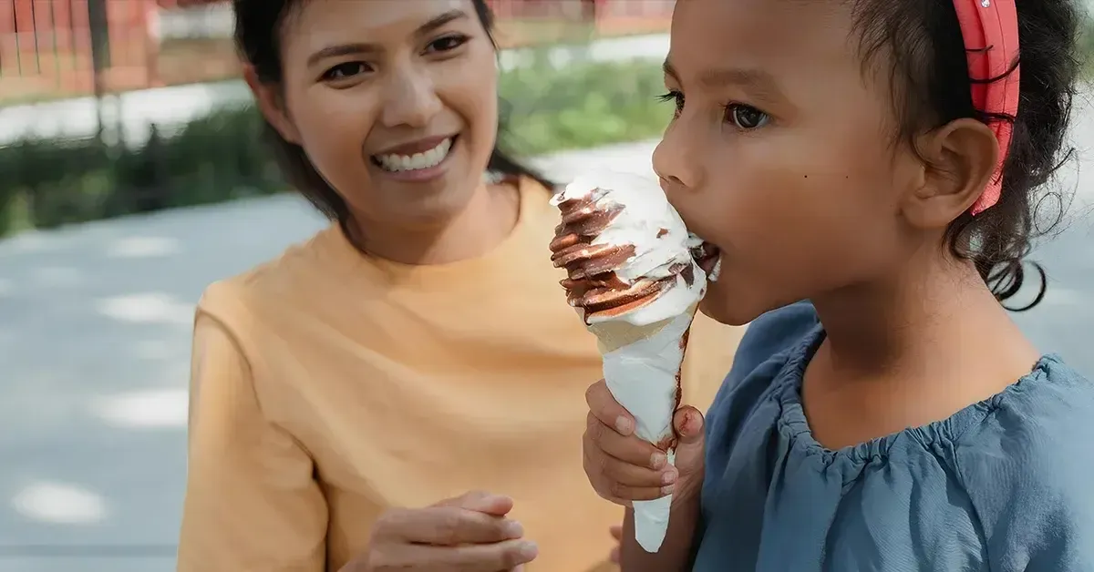 Mother giving her child ice cream as a sweet treat