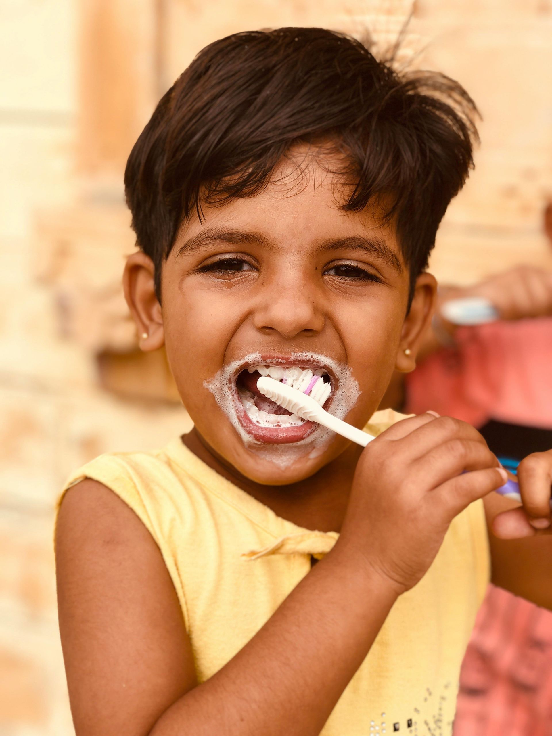 A little girl is brushing her teeth with a toothbrush