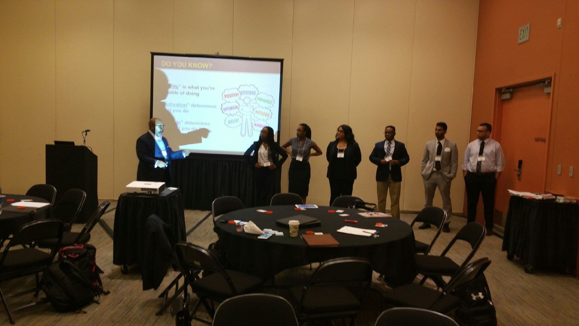 A group of people standing in front of a projector screen