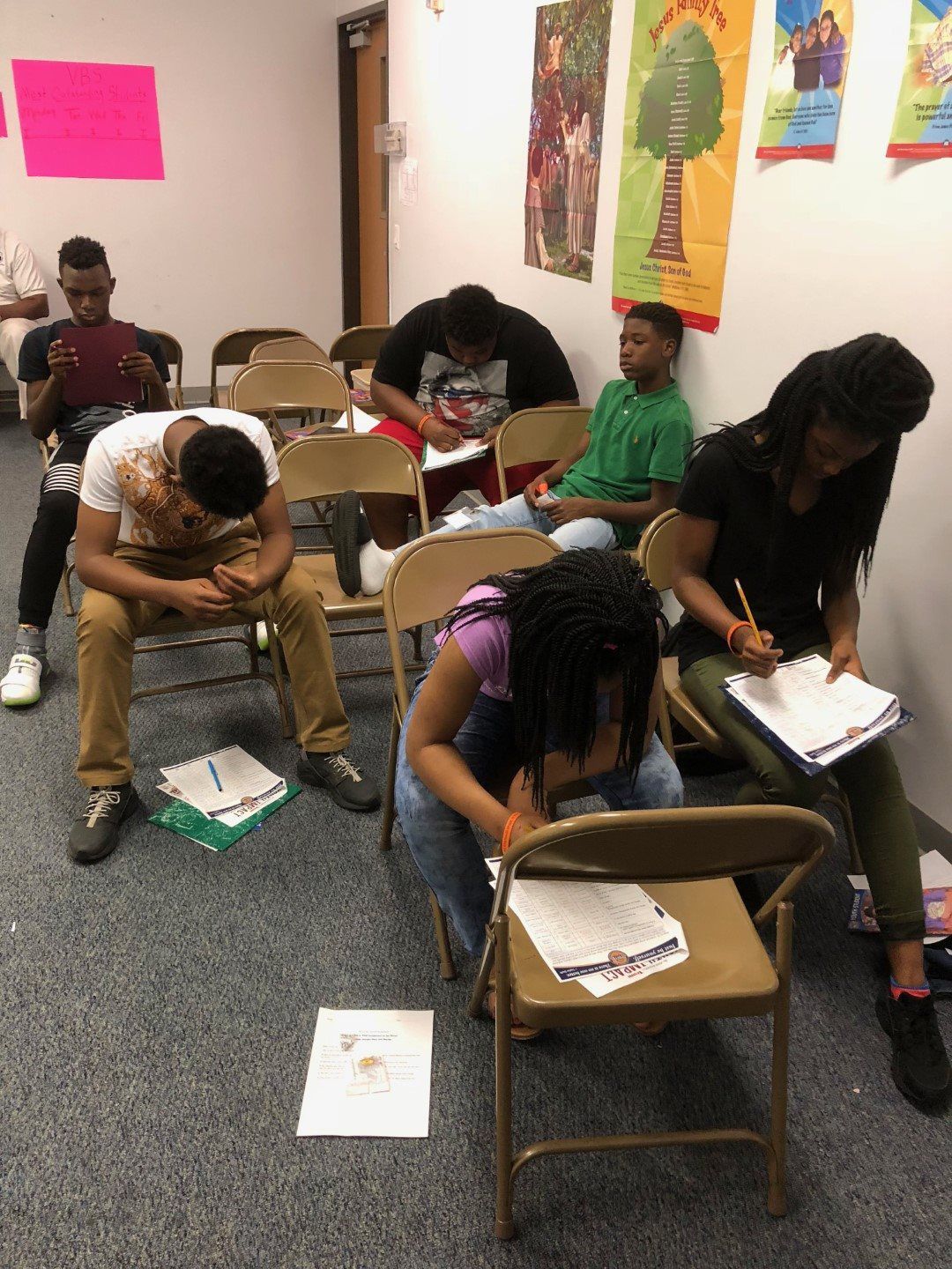 A group of people are sitting in folding chairs in a room.