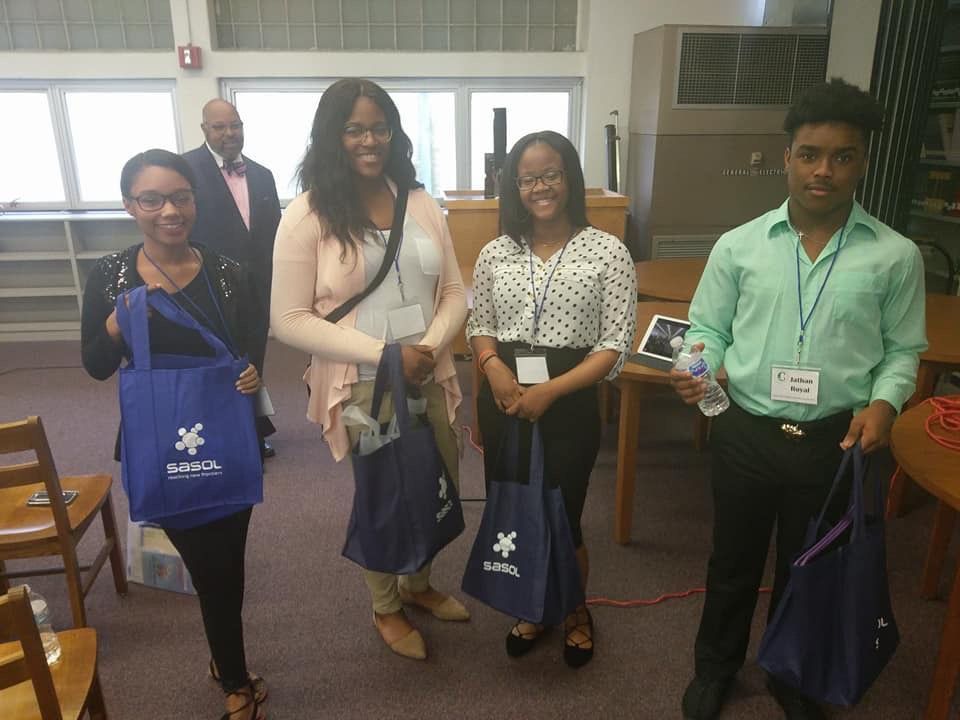A group of people standing in a room holding blue bags with a star on them