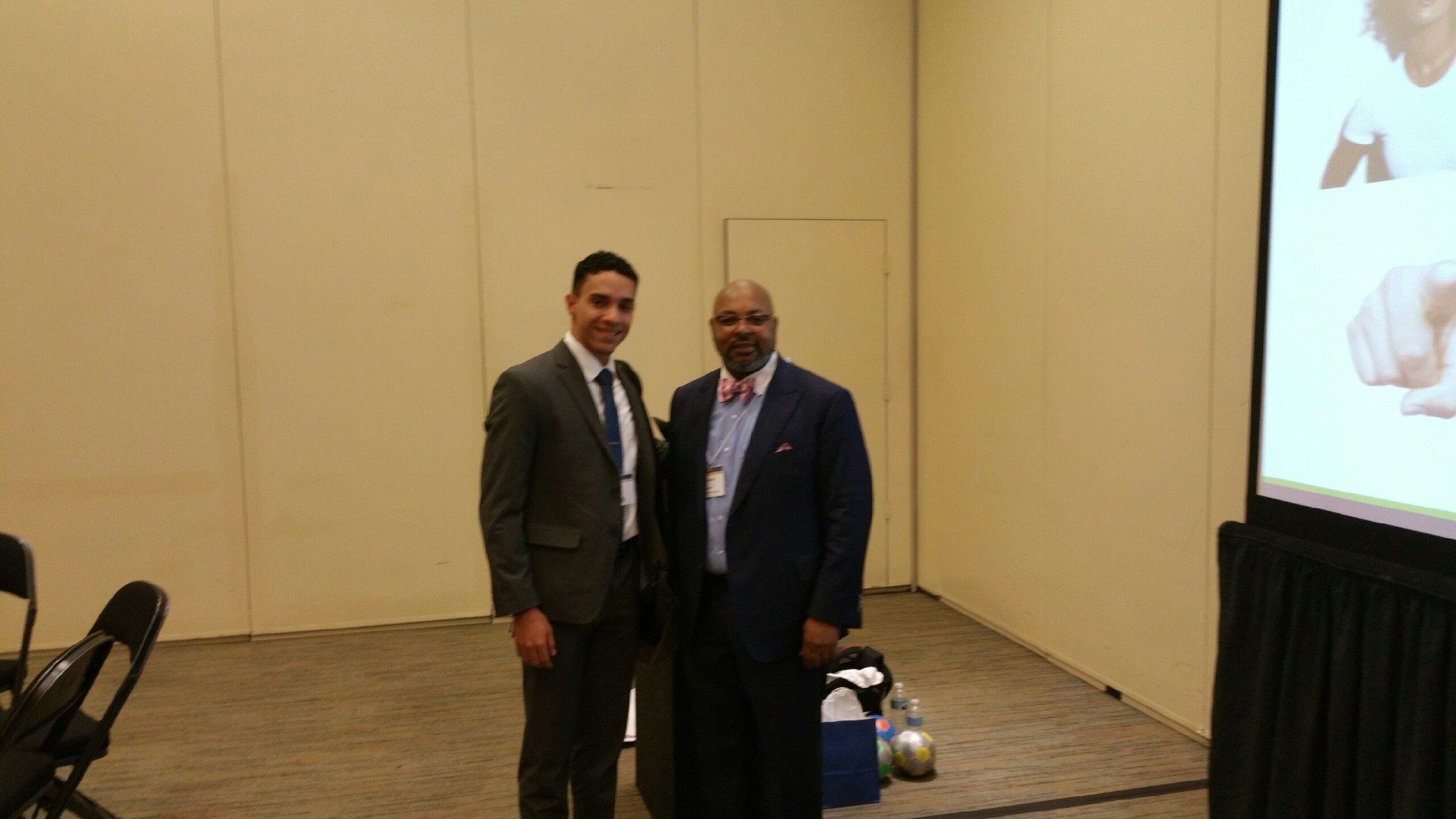 Two men in suits and bow ties are standing next to each other in a room.