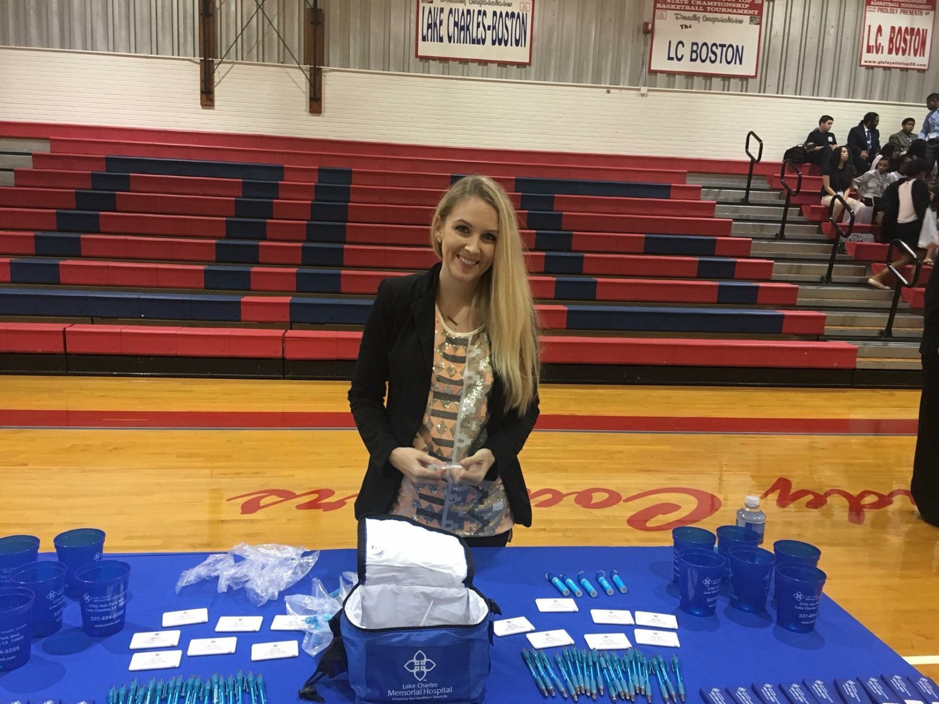 A woman is standing in front of a table in a gym.