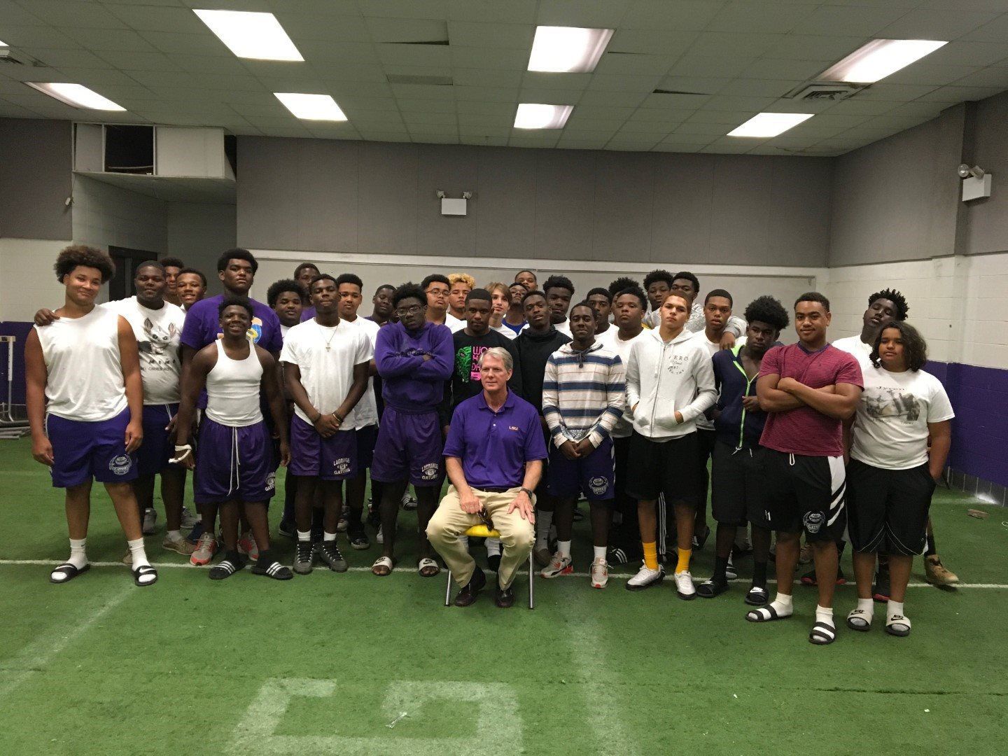 A group of people are posing for a picture in a gym.