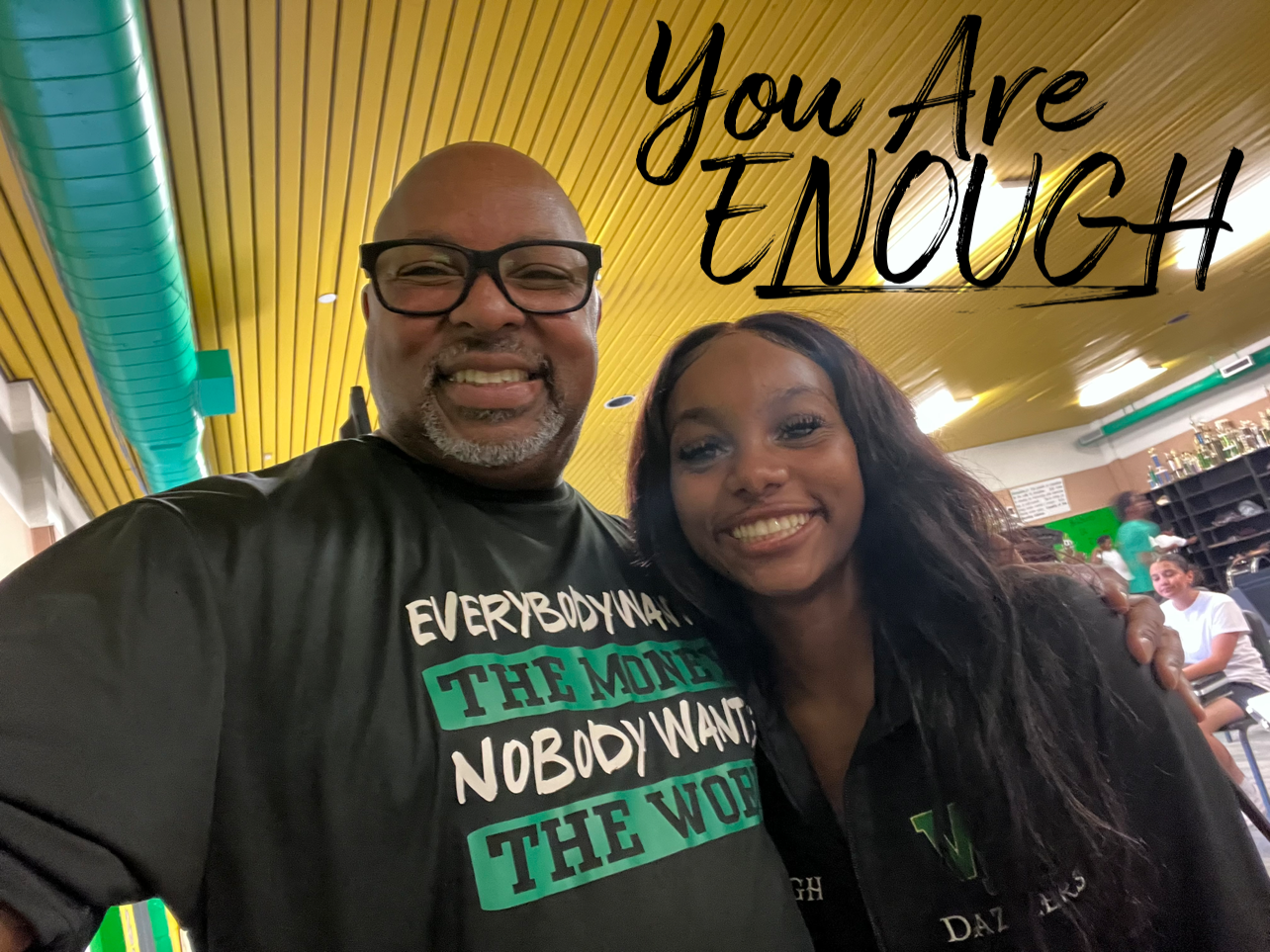 A man wearing glasses and a ring with the word team on it