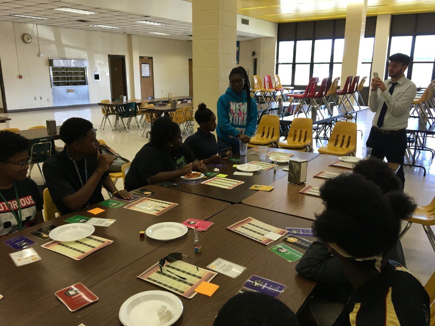 A group of people are sitting around a table in a cafeteria.