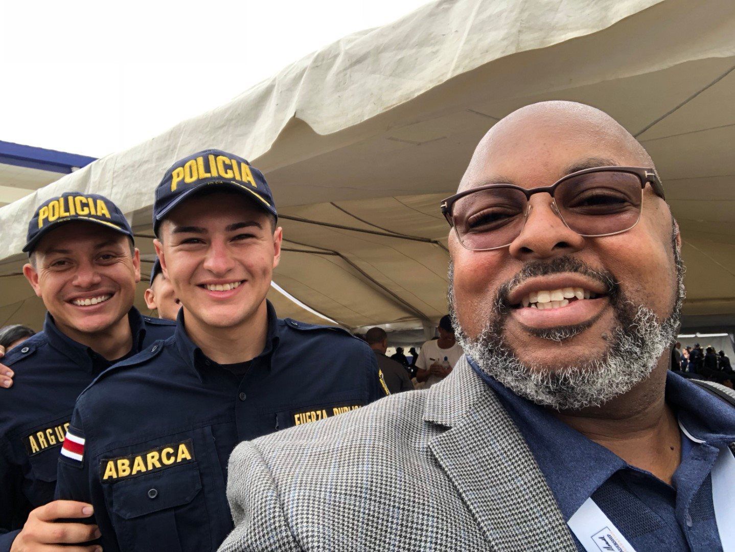 Three police officers are posing for a picture with a man in a suit.