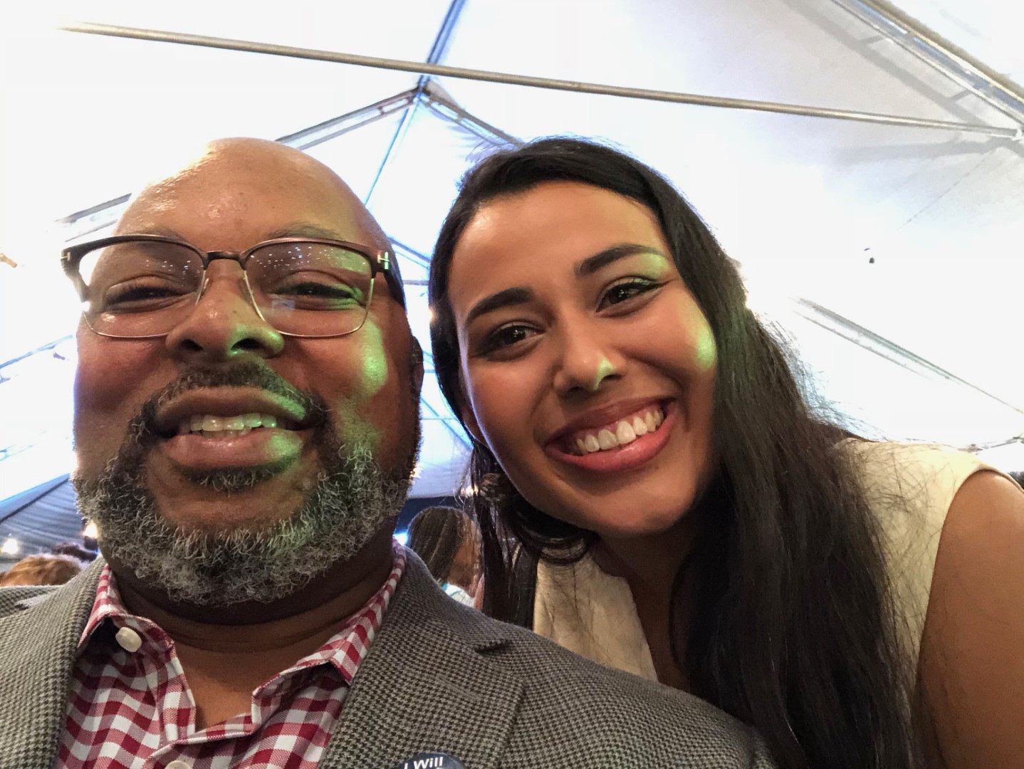 A man and a woman are posing for a picture and smiling.