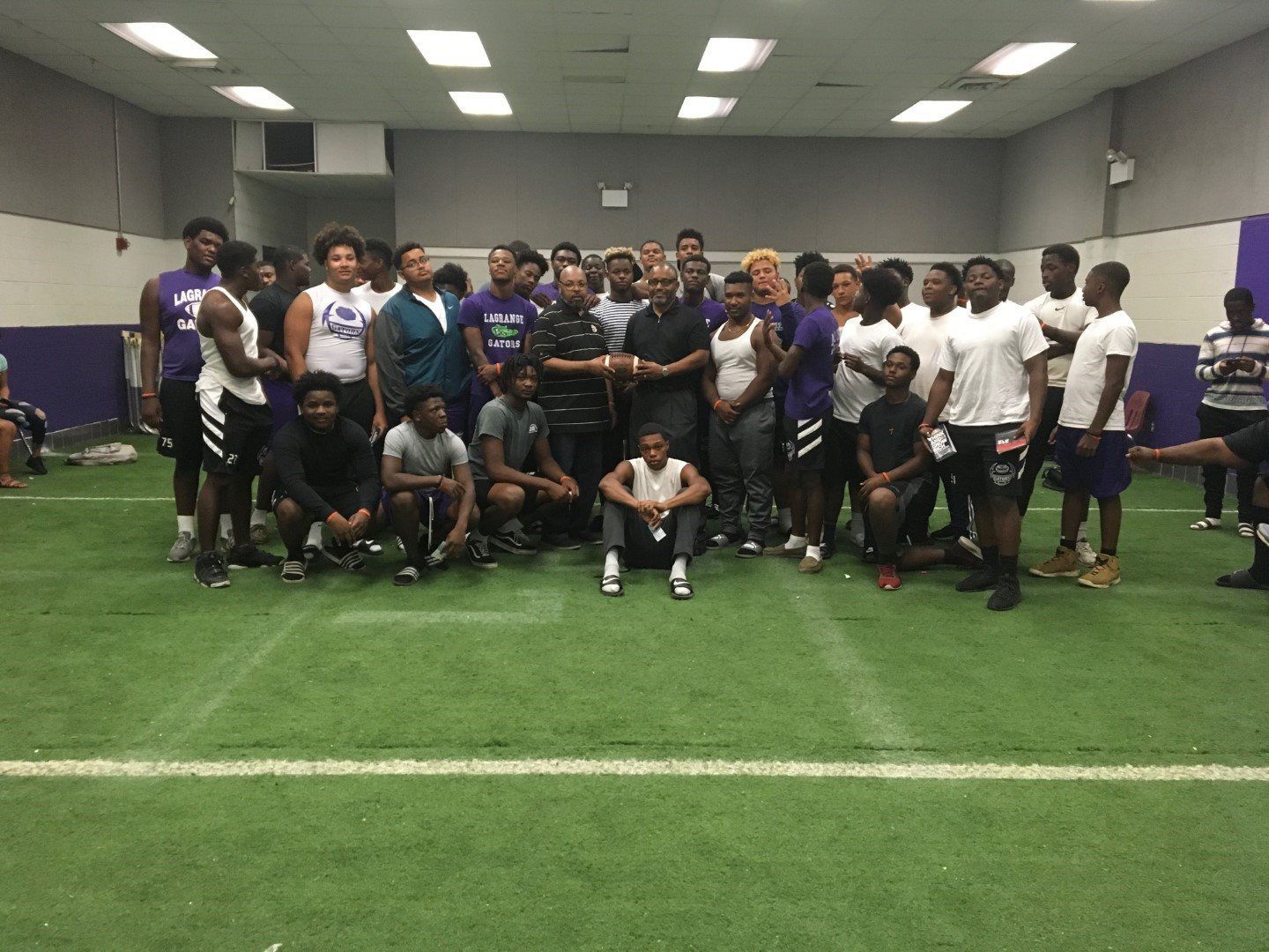 A group of people are posing for a picture in a gym.