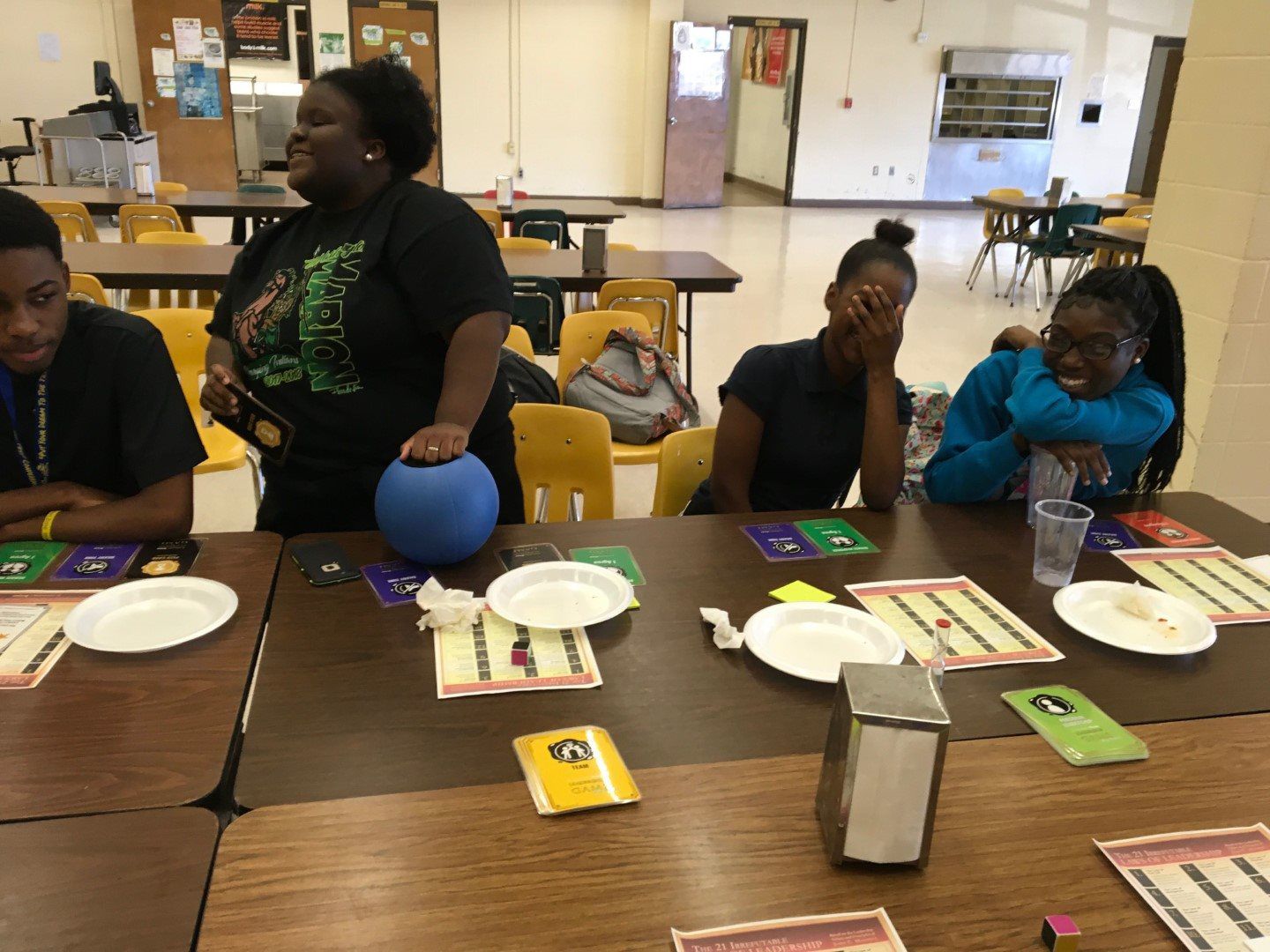 A group of people are sitting at a table with plates and napkins.