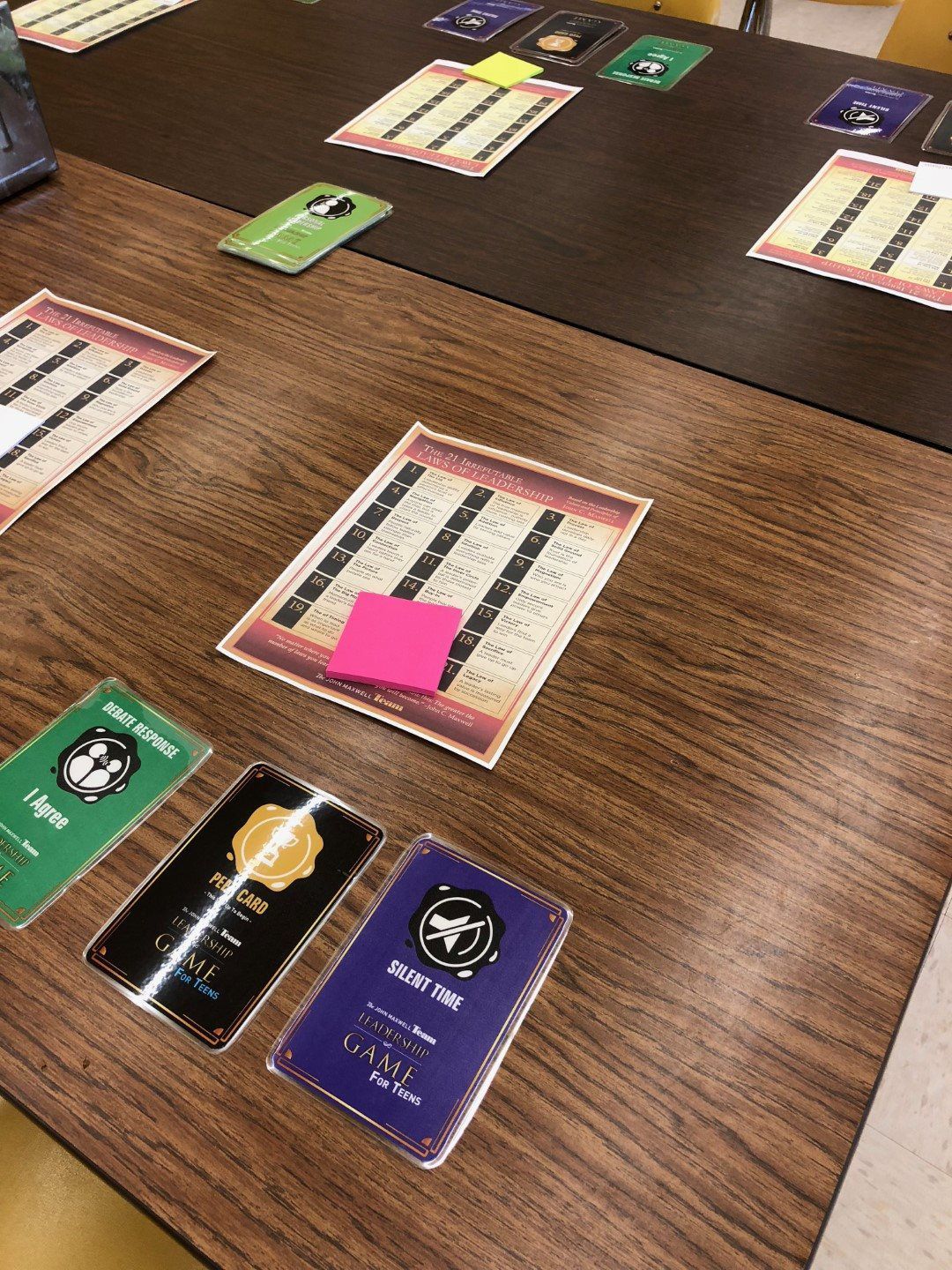A wooden table with a bunch of cards on it.