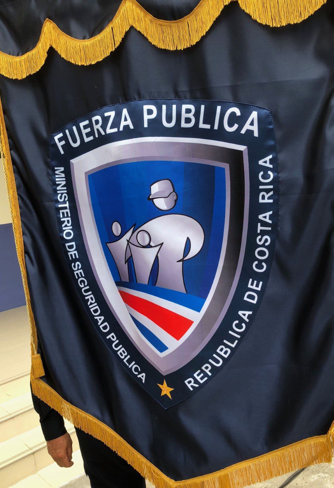 A person is holding a flag that says fuerza publica