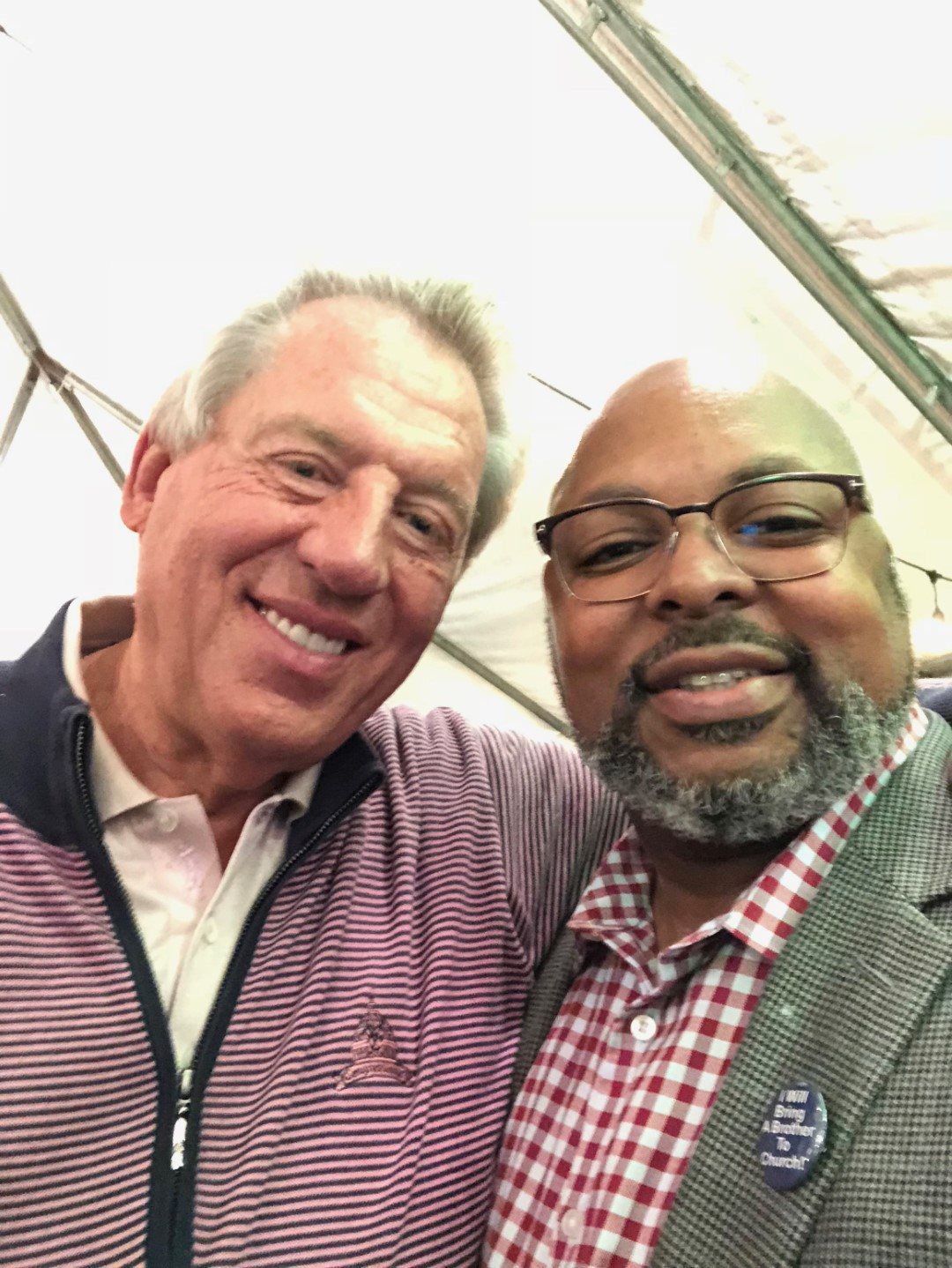 Two men are posing for a picture together and smiling.