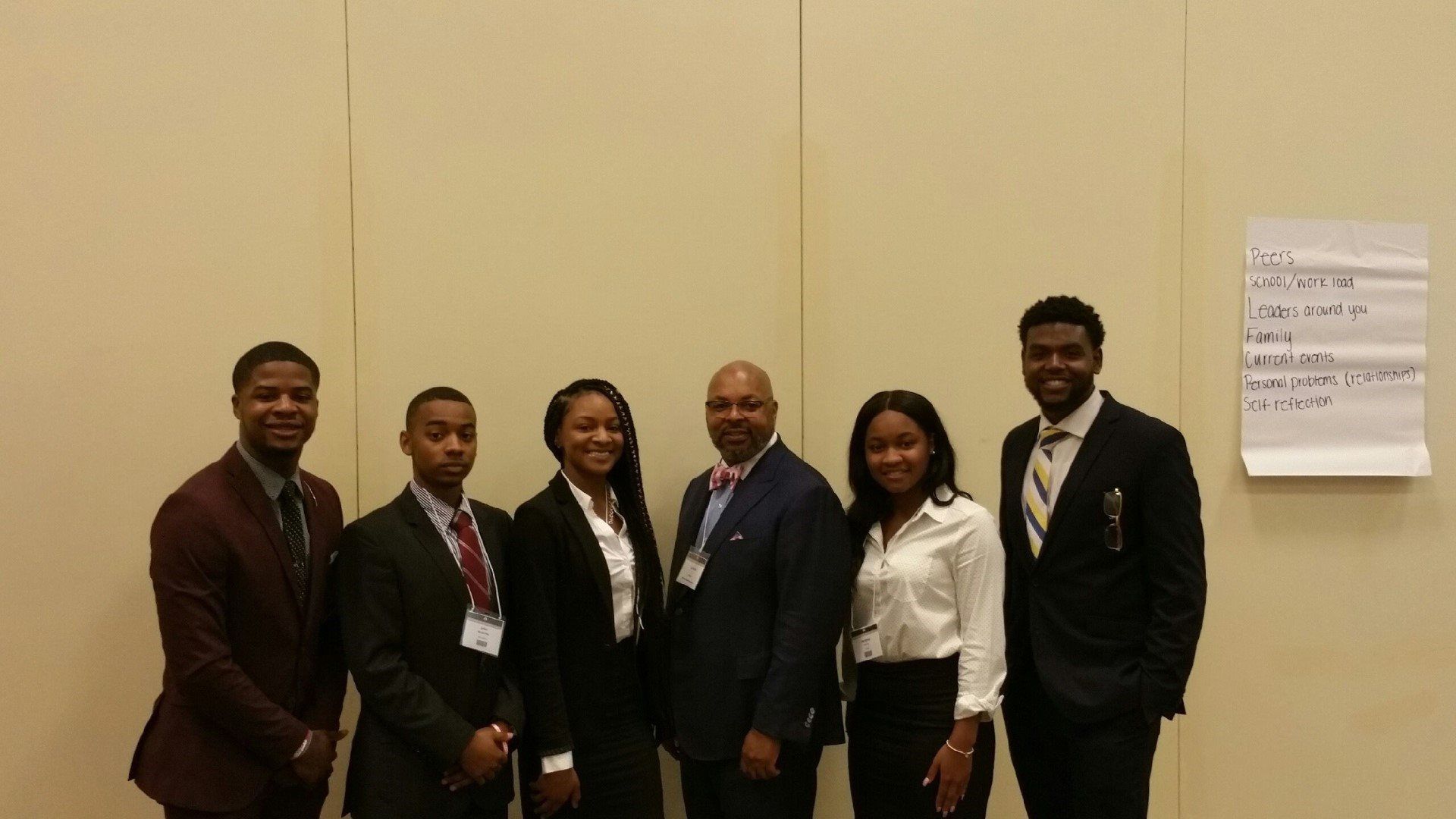 A group of people in suits and ties are posing for a picture.