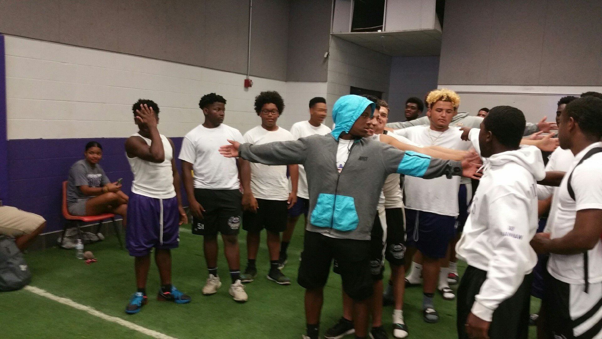 A group of young men are standing in a gym.