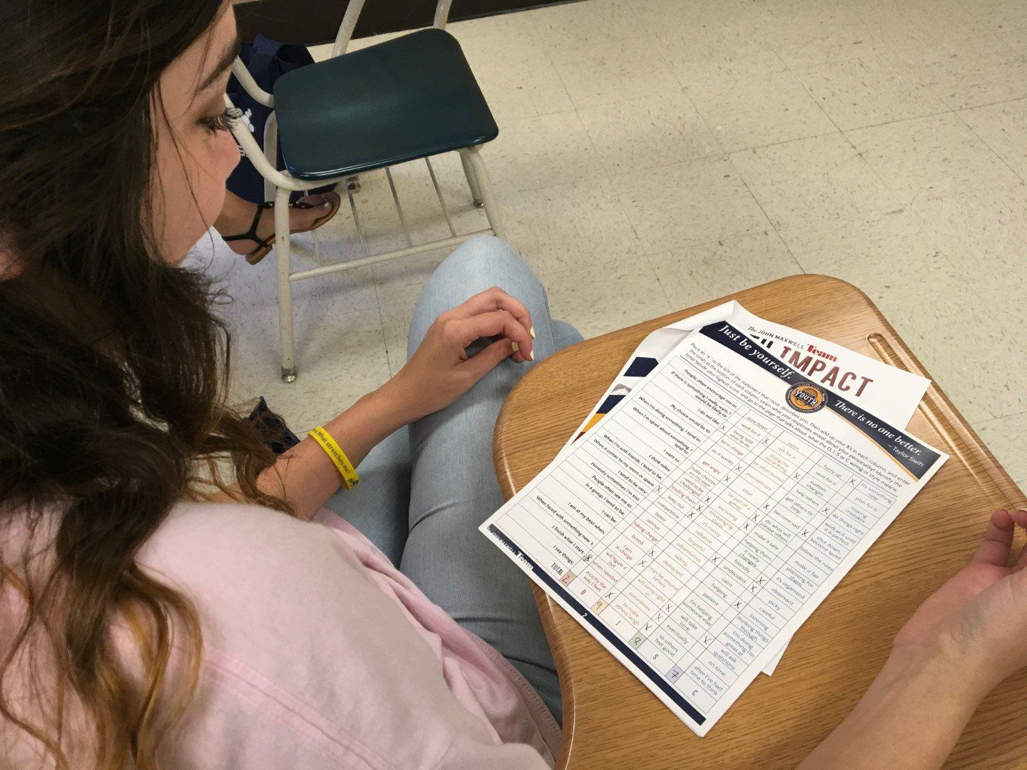 A woman is sitting at a desk with a piece of paper that says impact on it