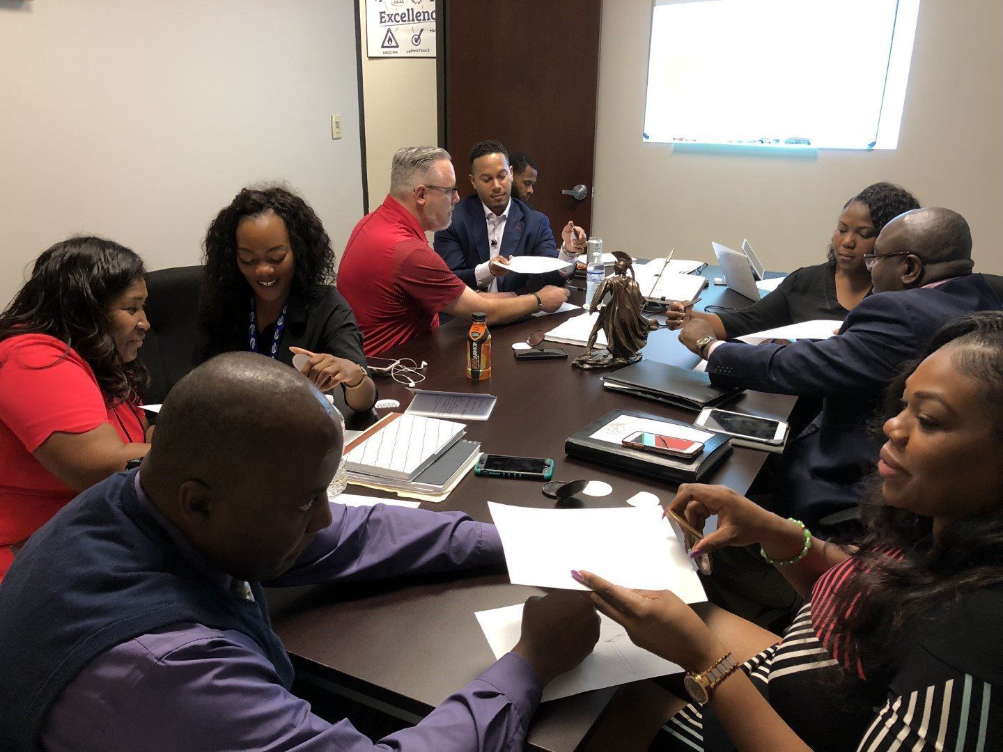 A group of people are sitting around a table having a meeting.