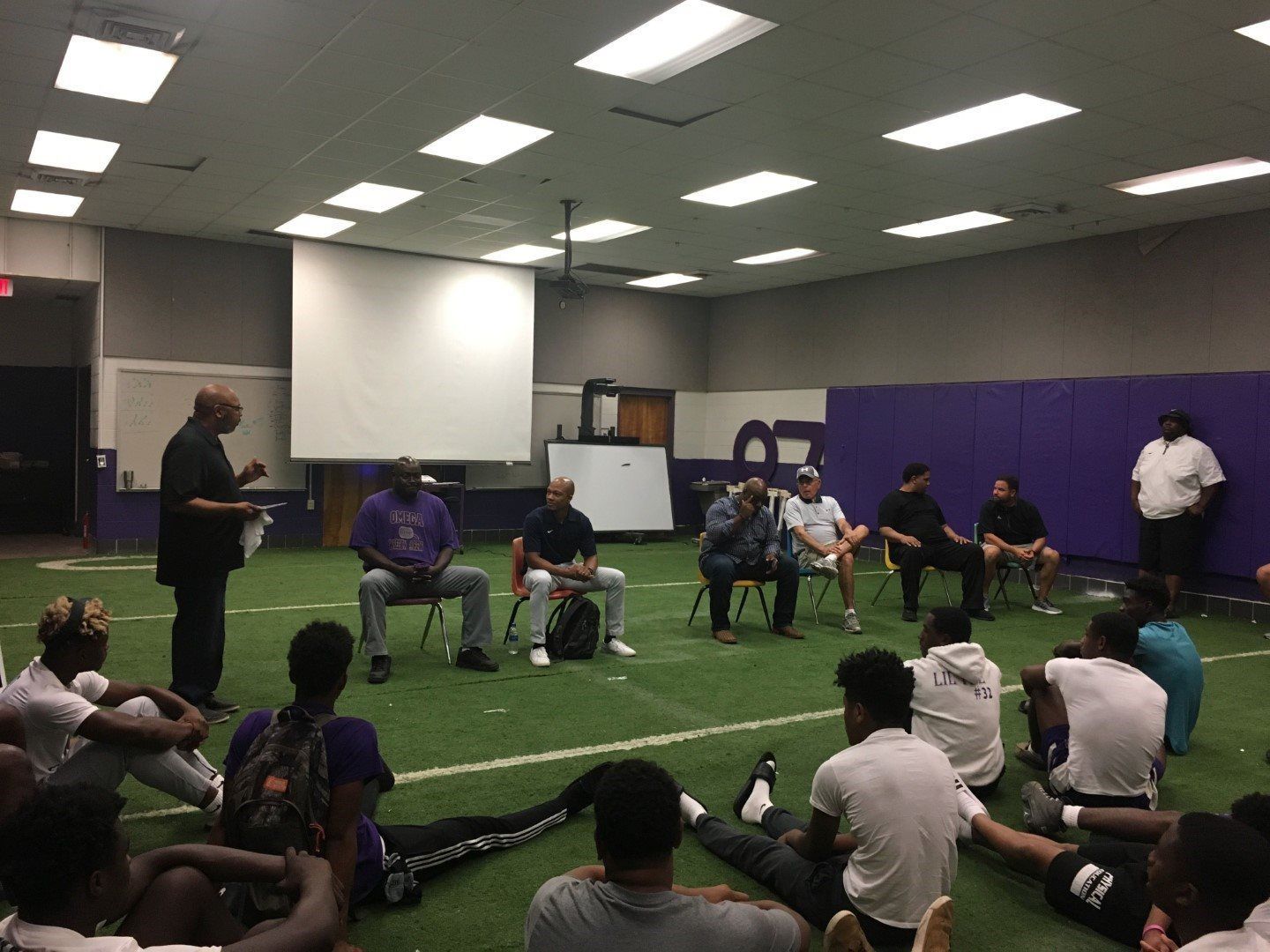 A group of people are sitting on the floor in a room.