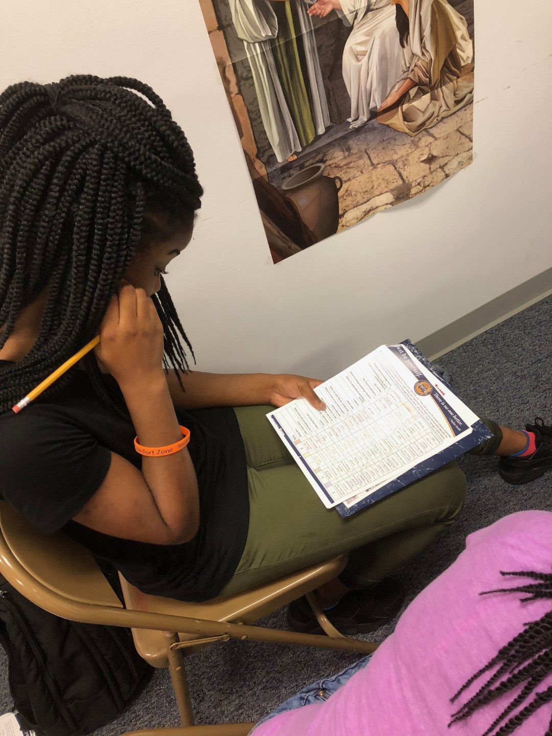 A woman is sitting in a chair reading a book
