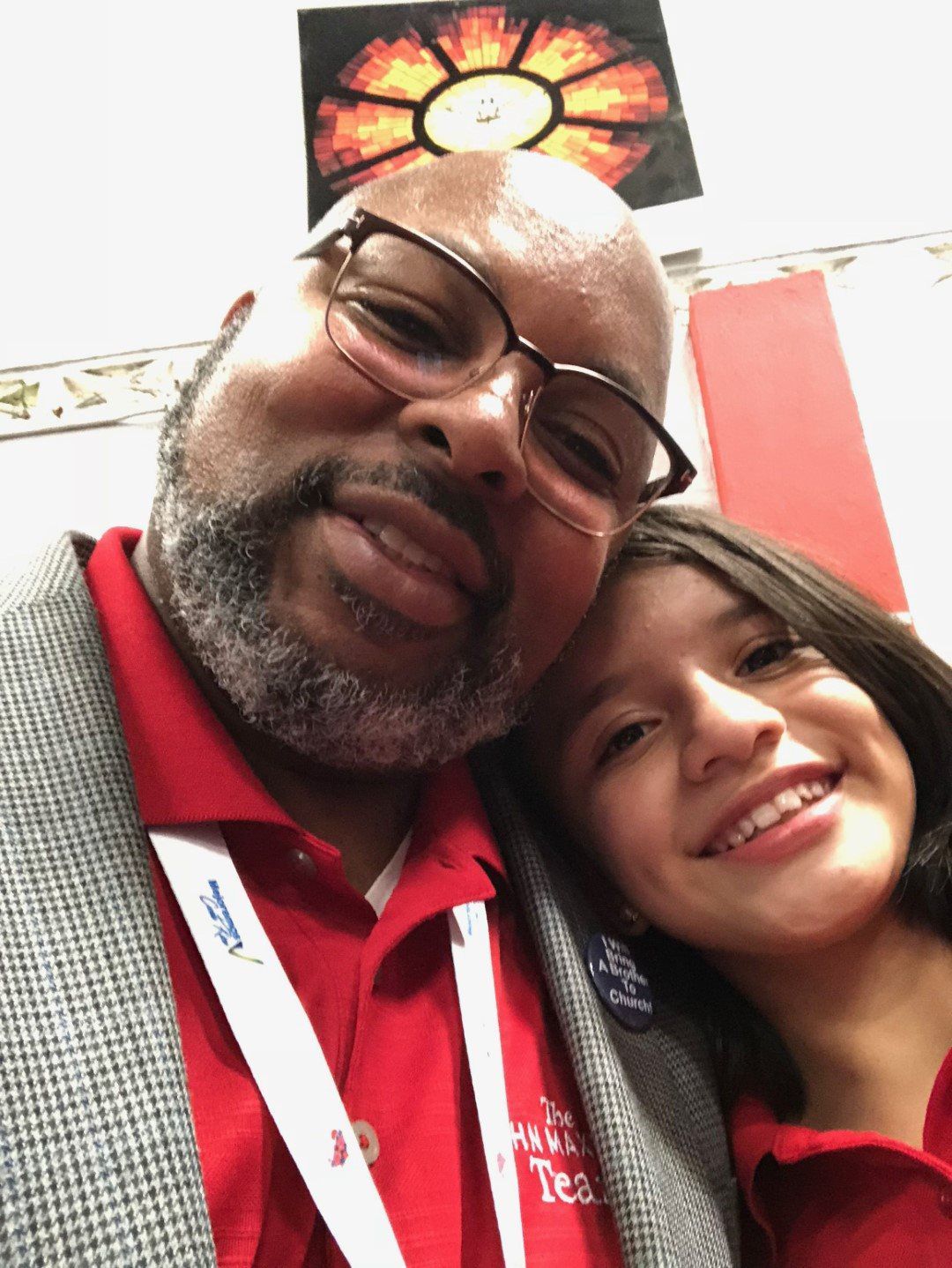 A man and a girl are posing for a picture and the man is wearing a lanyard that says jd