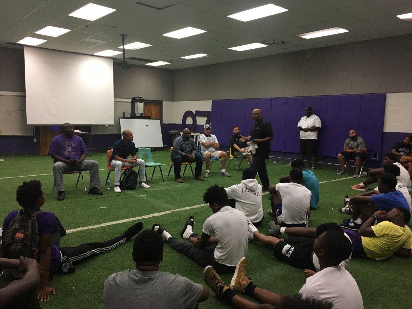 A group of people are sitting on the floor in a room.