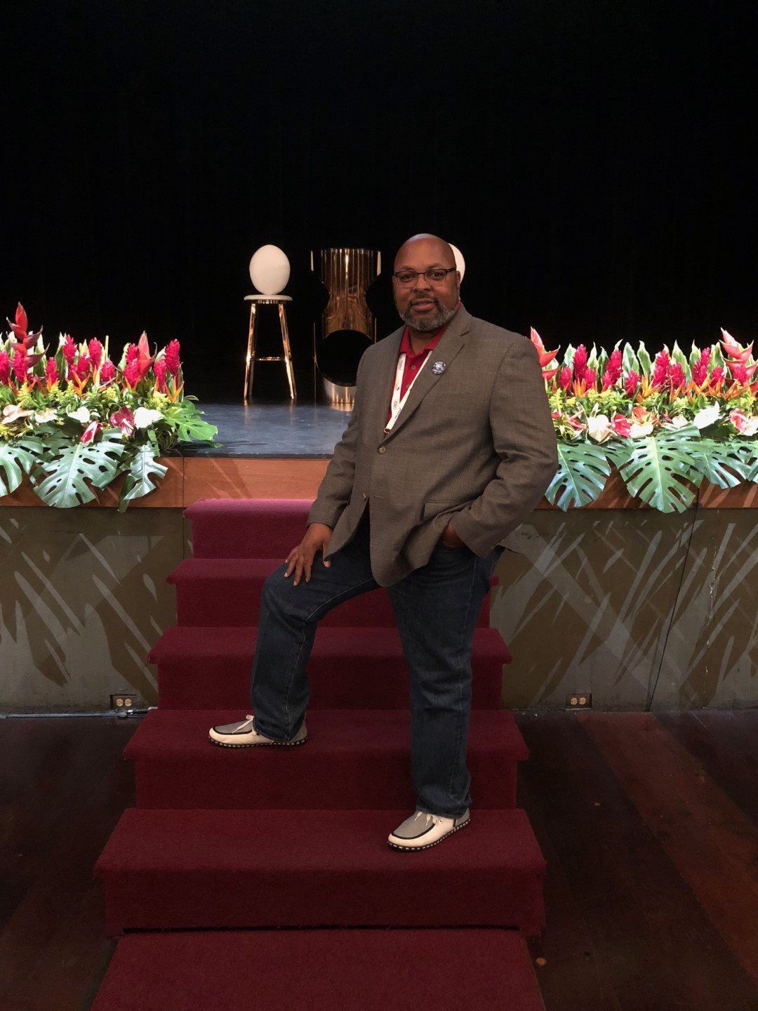 A man in a suit is standing on a set of stairs with his hands in his pockets.