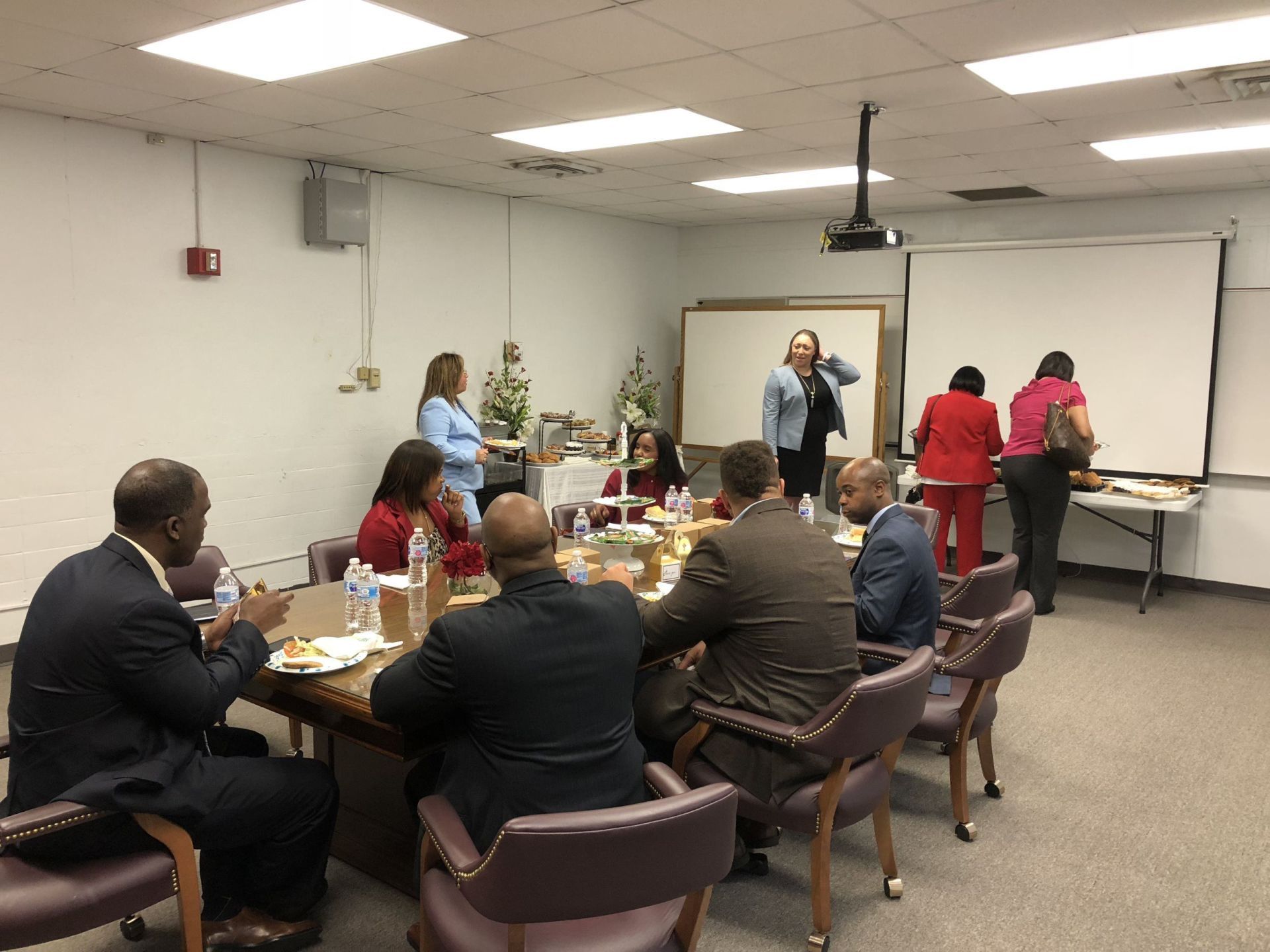 A group of people are sitting around a table in a room.